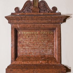 Zdjęcie nr 1: Epitafium w formie kamiennej tablicy w kształcie leżącego prostokąta, ujętej profilowanym obramieniem zwieńczonym krzyżem z parą wolut u podstawy, zdobionych motywem rozetek i liści akantu. Tablicę epitafijną pokrywa złocona inskrypcja „X(IĄDZ) FRANCISZEK SZOTTEK / Proboszcz Kanonik tyt(ularny): / V(ice) Dziekan Oświęcimski - / Dyrektor szkoły panieńskiej - / Obywatel honor(owy): Kęcki / umarł dnia 8. Listopada. 1876. / w roku życia swego - 68 lat. / będąc 5. lat Wikarym ½ roku Administratorem / i 36. lat Proboszczem przy tutejszym / Kościele i Kaplicy J(ana) Kantego. - / Prosi za duszę swoję o Ojcze Nasz i Zdrowaś Marya. –"
