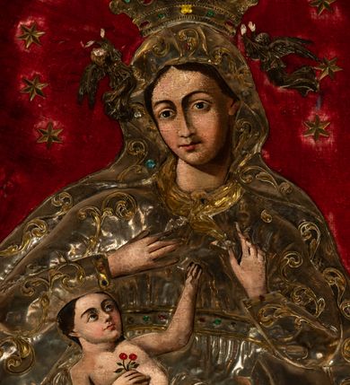 Zdjęcie nr 3: Obraz w kształcie stojącego prostokąta o wklęsło-wypukłej podstawie, zamkniętego nadwieszonym łukiem półkolistym, ujęty profilowaną, złoconą ramą przedstawia tronującą  Madonnę z Dzieciątkiem. Maria zwrócona jest na wprost o nieznacznie przechylonej w lewo sylwetce. Skierowaną w trzech czwartych w prawo, lekko przechyloną głowę charakteryzuje owalna twarz o silnym modelunku światłocieniowym, wyrazistych łukach brwiowych, dużych oczach, długim, prostym nosie i wąskiej linii ust  w odcieniu koralowym. Ciemne włosy rozdzielone są pośrodku głowy przedziałkiem. Partie szat Marii pokrywa metalowa osłona. Matka Boska ma na sobie srebrzoną suknię spiętą kameryzowanym paskiem, pod szyją jest zawiązana złocona chusta, a głowę, ramiona i nogi osłania srebrzony płaszcz zdobiony złoconym motywem wici roślinnej. Głowę Marii wieńczy zamknięta, kameryzowana korona podtrzymywana przez parę unoszących się po bokach aniołów. Prawą rękę składa na piersi, lewą unosi z wyprostowanym palcem wskazującym. Na kolanach Matki Boskiej leży zwrócone w lewo i spoglądające na nią Dzieciątko. Zaokrągloną twarz charakteryzują wyraziste łuki brwi, duże, ciemne oczy, lekko zadarty nos, kształtne usta i wyraźnie zaznaczony podbródek. Nagą sylwetkę Jezusa okrywa w partii bioder pokryte metalową osłoną, srebrzone perizonium. W prawej, złożonej na piersi dłoni trzyma gałązkę z dwoma kwiatkami czerwonej róży, lewą rękę wyciąga do góry, w kierunku dłoni Marii. Pod stopami Matki Boskiej jest złocony sierp półksiężyca, z tarczą słoneczną w formie rozety po lewej stronie kompozycji, poniżej srebrzone obłoki. Głowę Madonny okala krąg 12 gwiazd, po bokach, na wysokości ramion jest para wotów w kształcie serca. Tło wyłożone jest czerwonym aksamitem.   