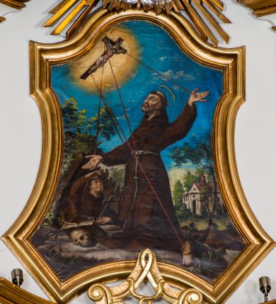 Zdjęcie nr 1: Obraz w kształcie trapezu o wklęsłych ramionach i podstawie oraz ściętych narożach dolnych, zamkniętego łukiem wklęsło-wypukłym, ujęty profilowaną, złoconą ramą zawiera scenę stygmatyzacji św. Franciszka z Asyżu. Ukazany pośrodku kompozycji święty klęczy zwrócony w trzech czwartych w prawo. Odchyloną do tyłu głowę charakteryzują owalna twarz o wyrazistych rysach i krótkim zaroście oraz tonsura. Święty ubrany jest w habit franciszkański przewiązany szarym sznurem. Na dłoniach rozłożonych na boki rąk, prawym boku tułowia oraz ubranej w sandał stopie lewej nogi widoczne są rany. Święty Franciszek ukazany jest na tle pejzażu. W lewym, górnym rogu kompozycji na tle błękitnego nieba unosi się krucyfiks ujęty promienistą glorią. Od pięciu ran ukrzyżowanego Jezusa biegną czerwone promienie w kierunku dłoni, boku i stóp św. Franciszka. Poniżej znajduje się grota, w której widoczna jest w półpostaci sylwetka spoglądającego na św. Franciszka brata Leona w lewej ręce trzymającego krzyż, prawą osłaniającego oczy. U stóp Franciszka, po lewej stronie leży czaszka ze wspartą na niej otwartą księgą. W głębi, po prawej stronie, pośród drzew widoczna jest bryła kościoła. 