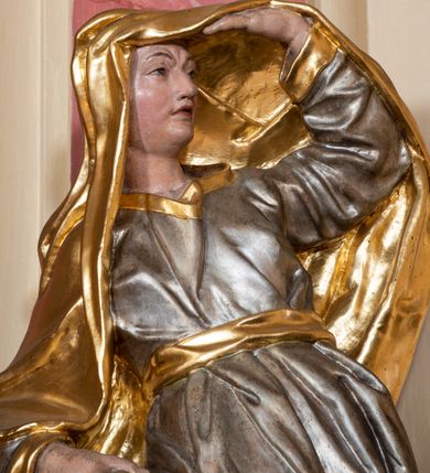 Zdjęcie nr 28: Nastawa ołtarzowa architektoniczna, dwukondygnacyjna, ze zwieńczeniem, pierwsza kondygnacja trójosiowa, druga jednoosiowa, ustawiona na dwustrefowym cokole z wyodrębnionymi, cylindrycznymi fragmentami, z bramkami na osiach bocznych. Ołtarz prostopadłościenny, murowany, z kamienną mensą i kamiennym portatylem. 
Pierwsza kondygnacja wydzielona czterema parami wklęsłych pilastrów o trzonach dekorowanych rocaille&#039;em i zwisami kwiatowymi oraz stojącymi na ich tle dwiema parami kolumn o kapitelach kompozytowych. Podpory dźwigają niepełne belkowanie, przerwane nad polami kondygnacji, obniżone nad zewnętrzną parą kolumn. Na skrajnej partii cokołu nastawy karbowane woluty z fantazyjnymi gruszkowatymi cokołami podtrzymującymi rocaille&#039;owe wazony. W polu środkowym głęboka wnęka w formie stojącego prostokąta zamkniętego łukiem odcinkowym podwójnie nadwieszonym z uskokiem, ujęta profilowaną ramą, z obrazem Ecce Homo w osobnej, podwójnej ramie. Nad nią kartusz rokokowy z napisem „In nomine Jesu / om(n)e Genu flec / tatur. ad Philipenses / Cap(ut) II”. Wnękę flankują figury Matki Boskiej i św. Marii Magdaleny ustawione na rocaille&#039;owych konsolach. Na osiach bocznych figura Dawida i grupa ofiary Izaaka na cokołach z nadlatującymi puttami nad nimi. Druga kondygnacja flankowana trzema parami pilastrów o trzonach przechodzących w spływy wolutowe i osobne woluty, opadające na belkowanie pierwszej kondygnacji, na których siedzą putta i anioły trzymające kartusze z napisami: „ET / GLORIA” i „SOLI / DEO / HONOR”. Kondygnacja zamknięta profilowanym gzymsem wyłamanym na ich osi oraz załamanym w dół nad polem. Na gzymsie fragmenty przerwanego, falistego przyczółka, na których siedzą anioły. W polu obraz św. Macieja w formie zbliżonej do trapezu o dwóch wypukłych bokach, ujęty profilowaną ramą. Pole flankowane akantem, powyżej rocaille&#039;owy kartusz z napisem: „IN / CRUCE / SALUS”. Zwieńczenie w formie zbliżonej do trapezu, o wklęsłych bokach, ujętych wolutami, zamknięte cęgowymi wolutami. W polu obraz Ukrzyżowania w formie zbliżonej do trapezu o dwóch wypukłych bokach, ujęty profilowaną ramą, flankowany akantem. Całość zamknięta płaskorzeźbionym przedstawieniem popiersia Boga Ojca oraz gołębicy Ducha Świętego w glorii, w otoku z obłoków i uskrzydlonych główek anielskich, w glorii promienistej, u dołu szarfa z napisem: „Hic est Filius meus dilectus in quo mihi bene complacui ipsum audite. Luc[a] XVII”. Struktura polichromowana w kolorze beżowym, dolna strefa cokołu brązowa, część trzonów pilastrów pomalowana na kolor jasnoróżowy; trzony kolumn, profile i ornamentyka złocone, detal srebrzony.  


