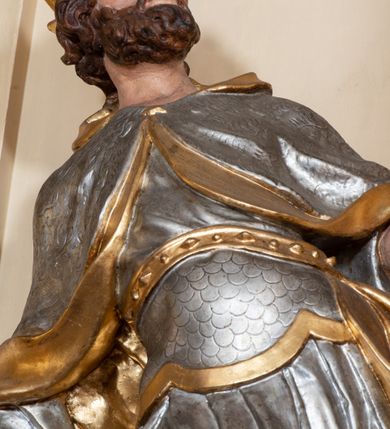 Zdjęcie nr 33: Nastawa ołtarzowa architektoniczna, dwukondygnacyjna, ze zwieńczeniem, pierwsza kondygnacja trójosiowa, druga jednoosiowa, ustawiona na dwustrefowym cokole z wyodrębnionymi, cylindrycznymi fragmentami, z bramkami na osiach bocznych. Ołtarz prostopadłościenny, murowany, z kamienną mensą i kamiennym portatylem. 
Pierwsza kondygnacja wydzielona czterema parami wklęsłych pilastrów o trzonach dekorowanych rocaille&#039;em i zwisami kwiatowymi oraz stojącymi na ich tle dwiema parami kolumn o kapitelach kompozytowych. Podpory dźwigają niepełne belkowanie, przerwane nad polami kondygnacji, obniżone nad zewnętrzną parą kolumn. Na skrajnej partii cokołu nastawy karbowane woluty z fantazyjnymi gruszkowatymi cokołami podtrzymującymi rocaille&#039;owe wazony. W polu środkowym głęboka wnęka w formie stojącego prostokąta zamkniętego łukiem odcinkowym podwójnie nadwieszonym z uskokiem, ujęta profilowaną ramą, z obrazem Ecce Homo w osobnej, podwójnej ramie. Nad nią kartusz rokokowy z napisem „In nomine Jesu / om(n)e Genu flec / tatur. ad Philipenses / Cap(ut) II”. Wnękę flankują figury Matki Boskiej i św. Marii Magdaleny ustawione na rocaille&#039;owych konsolach. Na osiach bocznych figura Dawida i grupa ofiary Izaaka na cokołach z nadlatującymi puttami nad nimi. Druga kondygnacja flankowana trzema parami pilastrów o trzonach przechodzących w spływy wolutowe i osobne woluty, opadające na belkowanie pierwszej kondygnacji, na których siedzą putta i anioły trzymające kartusze z napisami: „ET / GLORIA” i „SOLI / DEO / HONOR”. Kondygnacja zamknięta profilowanym gzymsem wyłamanym na ich osi oraz załamanym w dół nad polem. Na gzymsie fragmenty przerwanego, falistego przyczółka, na których siedzą anioły. W polu obraz św. Macieja w formie zbliżonej do trapezu o dwóch wypukłych bokach, ujęty profilowaną ramą. Pole flankowane akantem, powyżej rocaille&#039;owy kartusz z napisem: „IN / CRUCE / SALUS”. Zwieńczenie w formie zbliżonej do trapezu, o wklęsłych bokach, ujętych wolutami, zamknięte cęgowymi wolutami. W polu obraz Ukrzyżowania w formie zbliżonej do trapezu o dwóch wypukłych bokach, ujęty profilowaną ramą, flankowany akantem. Całość zamknięta płaskorzeźbionym przedstawieniem popiersia Boga Ojca oraz gołębicy Ducha Świętego w glorii, w otoku z obłoków i uskrzydlonych główek anielskich, w glorii promienistej, u dołu szarfa z napisem: „Hic est Filius meus dilectus in quo mihi bene complacui ipsum audite. Luc[a] XVII”. Struktura polichromowana w kolorze beżowym, dolna strefa cokołu brązowa, część trzonów pilastrów pomalowana na kolor jasnoróżowy; trzony kolumn, profile i ornamentyka złocone, detal srebrzony.  


