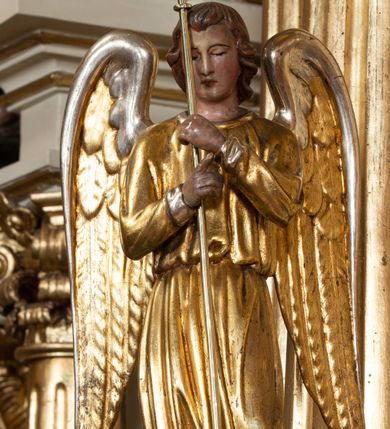 Zdjęcie nr 78: Nastawa ołtarzowa architektoniczna, dwukondygnacyjna, ze zwieńczeniem, pierwsza kondygnacja trójosiowa, druga jednoosiowa, ustawiona na dwustrefowym cokole z wyodrębnionymi, cylindrycznymi fragmentami, z bramkami na osiach bocznych. Ołtarz prostopadłościenny, murowany, z kamienną mensą i kamiennym portatylem. 
Pierwsza kondygnacja wydzielona czterema parami wklęsłych pilastrów o trzonach dekorowanych rocaille&#039;em i zwisami kwiatowymi oraz stojącymi na ich tle dwiema parami kolumn o kapitelach kompozytowych. Podpory dźwigają niepełne belkowanie, przerwane nad polami kondygnacji, obniżone nad zewnętrzną parą kolumn. Na skrajnej partii cokołu nastawy karbowane woluty z fantazyjnymi gruszkowatymi cokołami podtrzymującymi rocaille&#039;owe wazony. W polu środkowym głęboka wnęka w formie stojącego prostokąta zamkniętego łukiem odcinkowym podwójnie nadwieszonym z uskokiem, ujęta profilowaną ramą, z obrazem Ecce Homo w osobnej, podwójnej ramie. Nad nią kartusz rokokowy z napisem „In nomine Jesu / om(n)e Genu flec / tatur. ad Philipenses / Cap(ut) II”. Wnękę flankują figury Matki Boskiej i św. Marii Magdaleny ustawione na rocaille&#039;owych konsolach. Na osiach bocznych figura Dawida i grupa ofiary Izaaka na cokołach z nadlatującymi puttami nad nimi. Druga kondygnacja flankowana trzema parami pilastrów o trzonach przechodzących w spływy wolutowe i osobne woluty, opadające na belkowanie pierwszej kondygnacji, na których siedzą putta i anioły trzymające kartusze z napisami: „ET / GLORIA” i „SOLI / DEO / HONOR”. Kondygnacja zamknięta profilowanym gzymsem wyłamanym na ich osi oraz załamanym w dół nad polem. Na gzymsie fragmenty przerwanego, falistego przyczółka, na których siedzą anioły. W polu obraz św. Macieja w formie zbliżonej do trapezu o dwóch wypukłych bokach, ujęty profilowaną ramą. Pole flankowane akantem, powyżej rocaille&#039;owy kartusz z napisem: „IN / CRUCE / SALUS”. Zwieńczenie w formie zbliżonej do trapezu, o wklęsłych bokach, ujętych wolutami, zamknięte cęgowymi wolutami. W polu obraz Ukrzyżowania w formie zbliżonej do trapezu o dwóch wypukłych bokach, ujęty profilowaną ramą, flankowany akantem. Całość zamknięta płaskorzeźbionym przedstawieniem popiersia Boga Ojca oraz gołębicy Ducha Świętego w glorii, w otoku z obłoków i uskrzydlonych główek anielskich, w glorii promienistej, u dołu szarfa z napisem: „Hic est Filius meus dilectus in quo mihi bene complacui ipsum audite. Luc[a] XVII”. Struktura polichromowana w kolorze beżowym, dolna strefa cokołu brązowa, część trzonów pilastrów pomalowana na kolor jasnoróżowy; trzony kolumn, profile i ornamentyka złocone, detal srebrzony.  


