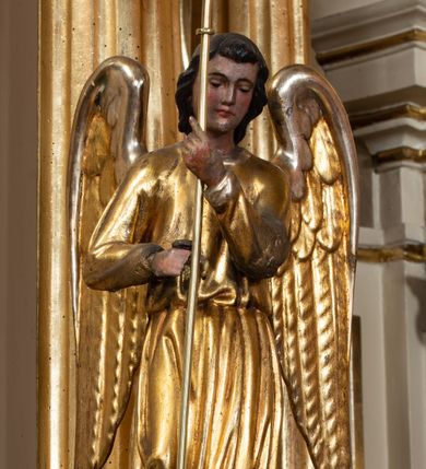 Zdjęcie nr 77: Nastawa ołtarzowa architektoniczna, dwukondygnacyjna, ze zwieńczeniem, pierwsza kondygnacja trójosiowa, druga jednoosiowa, ustawiona na dwustrefowym cokole z wyodrębnionymi, cylindrycznymi fragmentami, z bramkami na osiach bocznych. Ołtarz prostopadłościenny, murowany, z kamienną mensą i kamiennym portatylem. 
Pierwsza kondygnacja wydzielona czterema parami wklęsłych pilastrów o trzonach dekorowanych rocaille'em i zwisami kwiatowymi oraz stojącymi na ich tle dwiema parami kolumn o kapitelach kompozytowych. Podpory dźwigają niepełne belkowanie, przerwane nad polami kondygnacji, obniżone nad zewnętrzną parą kolumn. Na skrajnej partii cokołu nastawy karbowane woluty z fantazyjnymi gruszkowatymi cokołami podtrzymującymi rocaille'owe wazony. W polu środkowym głęboka wnęka w formie stojącego prostokąta zamkniętego łukiem odcinkowym podwójnie nadwieszonym z uskokiem, ujęta profilowaną ramą, z obrazem Ecce Homo w osobnej, podwójnej ramie. Nad nią kartusz rokokowy z napisem „In nomine Jesu / om(n)e Genu flec / tatur. ad Philipenses / Cap(ut) II”. Wnękę flankują figury Matki Boskiej i św. Marii Magdaleny ustawione na rocaille'owych konsolach. Na osiach bocznych figura Dawida i grupa ofiary Izaaka na cokołach z nadlatującymi puttami nad nimi. Druga kondygnacja flankowana trzema parami pilastrów o trzonach przechodzących w spływy wolutowe i osobne woluty, opadające na belkowanie pierwszej kondygnacji, na których siedzą putta i anioły trzymające kartusze z napisami: „ET / GLORIA” i „SOLI / DEO / HONOR”. Kondygnacja zamknięta profilowanym gzymsem wyłamanym na ich osi oraz załamanym w dół nad polem. Na gzymsie fragmenty przerwanego, falistego przyczółka, na których siedzą anioły. W polu obraz św. Macieja w formie zbliżonej do trapezu o dwóch wypukłych bokach, ujęty profilowaną ramą. Pole flankowane akantem, powyżej rocaille'owy kartusz z napisem: „IN / CRUCE / SALUS”. Zwieńczenie w formie zbliżonej do trapezu, o wklęsłych bokach, ujętych wolutami, zamknięte cęgowymi wolutami. W polu obraz Ukrzyżowania w formie zbliżonej do trapezu o dwóch wypukłych bokach, ujęty profilowaną ramą, flankowany akantem. Całość zamknięta płaskorzeźbionym przedstawieniem popiersia Boga Ojca oraz gołębicy Ducha Świętego w glorii, w otoku z obłoków i uskrzydlonych główek anielskich, w glorii promienistej, u dołu szarfa z napisem: „Hic est Filius meus dilectus in quo mihi bene complacui ipsum audite. Luc[a] XVII”. Struktura polichromowana w kolorze beżowym, dolna strefa cokołu brązowa, część trzonów pilastrów pomalowana na kolor jasnoróżowy; trzony kolumn, profile i ornamentyka złocone, detal srebrzony.  


