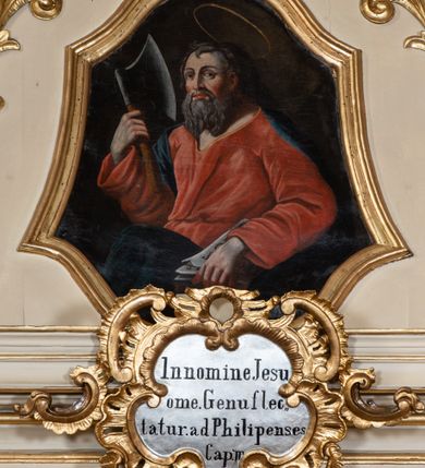 Zdjęcie nr 10: Nastawa ołtarzowa architektoniczna, dwukondygnacyjna, ze zwieńczeniem, pierwsza kondygnacja trójosiowa, druga jednoosiowa, ustawiona na dwustrefowym cokole z wyodrębnionymi, cylindrycznymi fragmentami, z bramkami na osiach bocznych. Ołtarz prostopadłościenny, murowany, z kamienną mensą i kamiennym portatylem. 
Pierwsza kondygnacja wydzielona czterema parami wklęsłych pilastrów o trzonach dekorowanych rocaille'em i zwisami kwiatowymi oraz stojącymi na ich tle dwiema parami kolumn o kapitelach kompozytowych. Podpory dźwigają niepełne belkowanie, przerwane nad polami kondygnacji, obniżone nad zewnętrzną parą kolumn. Na skrajnej partii cokołu nastawy karbowane woluty z fantazyjnymi gruszkowatymi cokołami podtrzymującymi rocaille'owe wazony. W polu środkowym głęboka wnęka w formie stojącego prostokąta zamkniętego łukiem odcinkowym podwójnie nadwieszonym z uskokiem, ujęta profilowaną ramą, z obrazem Ecce Homo w osobnej, podwójnej ramie. Nad nią kartusz rokokowy z napisem „In nomine Jesu / om(n)e Genu flec / tatur. ad Philipenses / Cap(ut) II”. Wnękę flankują figury Matki Boskiej i św. Marii Magdaleny ustawione na rocaille'owych konsolach. Na osiach bocznych figura Dawida i grupa ofiary Izaaka na cokołach z nadlatującymi puttami nad nimi. Druga kondygnacja flankowana trzema parami pilastrów o trzonach przechodzących w spływy wolutowe i osobne woluty, opadające na belkowanie pierwszej kondygnacji, na których siedzą putta i anioły trzymające kartusze z napisami: „ET / GLORIA” i „SOLI / DEO / HONOR”. Kondygnacja zamknięta profilowanym gzymsem wyłamanym na ich osi oraz załamanym w dół nad polem. Na gzymsie fragmenty przerwanego, falistego przyczółka, na których siedzą anioły. W polu obraz św. Macieja w formie zbliżonej do trapezu o dwóch wypukłych bokach, ujęty profilowaną ramą. Pole flankowane akantem, powyżej rocaille'owy kartusz z napisem: „IN / CRUCE / SALUS”. Zwieńczenie w formie zbliżonej do trapezu, o wklęsłych bokach, ujętych wolutami, zamknięte cęgowymi wolutami. W polu obraz Ukrzyżowania w formie zbliżonej do trapezu o dwóch wypukłych bokach, ujęty profilowaną ramą, flankowany akantem. Całość zamknięta płaskorzeźbionym przedstawieniem popiersia Boga Ojca oraz gołębicy Ducha Świętego w glorii, w otoku z obłoków i uskrzydlonych główek anielskich, w glorii promienistej, u dołu szarfa z napisem: „Hic est Filius meus dilectus in quo mihi bene complacui ipsum audite. Luc[a] XVII”. Struktura polichromowana w kolorze beżowym, dolna strefa cokołu brązowa, część trzonów pilastrów pomalowana na kolor jasnoróżowy; trzony kolumn, profile i ornamentyka złocone, detal srebrzony.  


