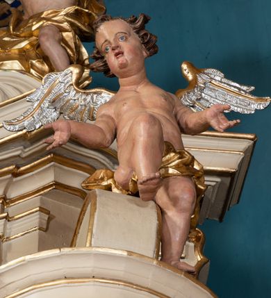 Zdjęcie nr 59: Nastawa ołtarzowa architektoniczna, dwukondygnacyjna, ze zwieńczeniem, pierwsza kondygnacja trójosiowa, druga jednoosiowa, ustawiona na dwustrefowym cokole z wyodrębnionymi, cylindrycznymi fragmentami, z bramkami na osiach bocznych. Ołtarz prostopadłościenny, murowany, z kamienną mensą i kamiennym portatylem. 
Pierwsza kondygnacja wydzielona czterema parami wklęsłych pilastrów o trzonach dekorowanych rocaille'em i zwisami kwiatowymi oraz stojącymi na ich tle dwiema parami kolumn o kapitelach kompozytowych. Podpory dźwigają niepełne belkowanie, przerwane nad polami kondygnacji, obniżone nad zewnętrzną parą kolumn. Na skrajnej partii cokołu nastawy karbowane woluty z fantazyjnymi gruszkowatymi cokołami podtrzymującymi rocaille'owe wazony. W polu środkowym głęboka wnęka w formie stojącego prostokąta zamkniętego łukiem odcinkowym podwójnie nadwieszonym z uskokiem, ujęta profilowaną ramą, z obrazem Ecce Homo w osobnej, podwójnej ramie. Nad nią kartusz rokokowy z napisem „In nomine Jesu / om(n)e Genu flec / tatur. ad Philipenses / Cap(ut) II”. Wnękę flankują figury Matki Boskiej i św. Marii Magdaleny ustawione na rocaille'owych konsolach. Na osiach bocznych figura Dawida i grupa ofiary Izaaka na cokołach z nadlatującymi puttami nad nimi. Druga kondygnacja flankowana trzema parami pilastrów o trzonach przechodzących w spływy wolutowe i osobne woluty, opadające na belkowanie pierwszej kondygnacji, na których siedzą putta i anioły trzymające kartusze z napisami: „ET / GLORIA” i „SOLI / DEO / HONOR”. Kondygnacja zamknięta profilowanym gzymsem wyłamanym na ich osi oraz załamanym w dół nad polem. Na gzymsie fragmenty przerwanego, falistego przyczółka, na których siedzą anioły. W polu obraz św. Macieja w formie zbliżonej do trapezu o dwóch wypukłych bokach, ujęty profilowaną ramą. Pole flankowane akantem, powyżej rocaille'owy kartusz z napisem: „IN / CRUCE / SALUS”. Zwieńczenie w formie zbliżonej do trapezu, o wklęsłych bokach, ujętych wolutami, zamknięte cęgowymi wolutami. W polu obraz Ukrzyżowania w formie zbliżonej do trapezu o dwóch wypukłych bokach, ujęty profilowaną ramą, flankowany akantem. Całość zamknięta płaskorzeźbionym przedstawieniem popiersia Boga Ojca oraz gołębicy Ducha Świętego w glorii, w otoku z obłoków i uskrzydlonych główek anielskich, w glorii promienistej, u dołu szarfa z napisem: „Hic est Filius meus dilectus in quo mihi bene complacui ipsum audite. Luc[a] XVII”. Struktura polichromowana w kolorze beżowym, dolna strefa cokołu brązowa, część trzonów pilastrów pomalowana na kolor jasnoróżowy; trzony kolumn, profile i ornamentyka złocone, detal srebrzony.  


