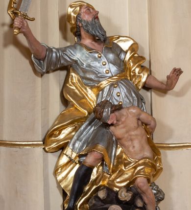 Zdjęcie nr 44: Nastawa ołtarzowa architektoniczna, dwukondygnacyjna, ze zwieńczeniem, pierwsza kondygnacja trójosiowa, druga jednoosiowa, ustawiona na dwustrefowym cokole z wyodrębnionymi, cylindrycznymi fragmentami, z bramkami na osiach bocznych. Ołtarz prostopadłościenny, murowany, z kamienną mensą i kamiennym portatylem. 
Pierwsza kondygnacja wydzielona czterema parami wklęsłych pilastrów o trzonach dekorowanych rocaille&#039;em i zwisami kwiatowymi oraz stojącymi na ich tle dwiema parami kolumn o kapitelach kompozytowych. Podpory dźwigają niepełne belkowanie, przerwane nad polami kondygnacji, obniżone nad zewnętrzną parą kolumn. Na skrajnej partii cokołu nastawy karbowane woluty z fantazyjnymi gruszkowatymi cokołami podtrzymującymi rocaille&#039;owe wazony. W polu środkowym głęboka wnęka w formie stojącego prostokąta zamkniętego łukiem odcinkowym podwójnie nadwieszonym z uskokiem, ujęta profilowaną ramą, z obrazem Ecce Homo w osobnej, podwójnej ramie. Nad nią kartusz rokokowy z napisem „In nomine Jesu / om(n)e Genu flec / tatur. ad Philipenses / Cap(ut) II”. Wnękę flankują figury Matki Boskiej i św. Marii Magdaleny ustawione na rocaille&#039;owych konsolach. Na osiach bocznych figura Dawida i grupa ofiary Izaaka na cokołach z nadlatującymi puttami nad nimi. Druga kondygnacja flankowana trzema parami pilastrów o trzonach przechodzących w spływy wolutowe i osobne woluty, opadające na belkowanie pierwszej kondygnacji, na których siedzą putta i anioły trzymające kartusze z napisami: „ET / GLORIA” i „SOLI / DEO / HONOR”. Kondygnacja zamknięta profilowanym gzymsem wyłamanym na ich osi oraz załamanym w dół nad polem. Na gzymsie fragmenty przerwanego, falistego przyczółka, na których siedzą anioły. W polu obraz św. Macieja w formie zbliżonej do trapezu o dwóch wypukłych bokach, ujęty profilowaną ramą. Pole flankowane akantem, powyżej rocaille&#039;owy kartusz z napisem: „IN / CRUCE / SALUS”. Zwieńczenie w formie zbliżonej do trapezu, o wklęsłych bokach, ujętych wolutami, zamknięte cęgowymi wolutami. W polu obraz Ukrzyżowania w formie zbliżonej do trapezu o dwóch wypukłych bokach, ujęty profilowaną ramą, flankowany akantem. Całość zamknięta płaskorzeźbionym przedstawieniem popiersia Boga Ojca oraz gołębicy Ducha Świętego w glorii, w otoku z obłoków i uskrzydlonych główek anielskich, w glorii promienistej, u dołu szarfa z napisem: „Hic est Filius meus dilectus in quo mihi bene complacui ipsum audite. Luc[a] XVII”. Struktura polichromowana w kolorze beżowym, dolna strefa cokołu brązowa, część trzonów pilastrów pomalowana na kolor jasnoróżowy; trzony kolumn, profile i ornamentyka złocone, detal srebrzony.  


