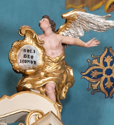 Zdjęcie nr 53: Nastawa ołtarzowa architektoniczna, dwukondygnacyjna, ze zwieńczeniem, pierwsza kondygnacja trójosiowa, druga jednoosiowa, ustawiona na dwustrefowym cokole z wyodrębnionymi, cylindrycznymi fragmentami, z bramkami na osiach bocznych. Ołtarz prostopadłościenny, murowany, z kamienną mensą i kamiennym portatylem. 
Pierwsza kondygnacja wydzielona czterema parami wklęsłych pilastrów o trzonach dekorowanych rocaille'em i zwisami kwiatowymi oraz stojącymi na ich tle dwiema parami kolumn o kapitelach kompozytowych. Podpory dźwigają niepełne belkowanie, przerwane nad polami kondygnacji, obniżone nad zewnętrzną parą kolumn. Na skrajnej partii cokołu nastawy karbowane woluty z fantazyjnymi gruszkowatymi cokołami podtrzymującymi rocaille'owe wazony. W polu środkowym głęboka wnęka w formie stojącego prostokąta zamkniętego łukiem odcinkowym podwójnie nadwieszonym z uskokiem, ujęta profilowaną ramą, z obrazem Ecce Homo w osobnej, podwójnej ramie. Nad nią kartusz rokokowy z napisem „In nomine Jesu / om(n)e Genu flec / tatur. ad Philipenses / Cap(ut) II”. Wnękę flankują figury Matki Boskiej i św. Marii Magdaleny ustawione na rocaille'owych konsolach. Na osiach bocznych figura Dawida i grupa ofiary Izaaka na cokołach z nadlatującymi puttami nad nimi. Druga kondygnacja flankowana trzema parami pilastrów o trzonach przechodzących w spływy wolutowe i osobne woluty, opadające na belkowanie pierwszej kondygnacji, na których siedzą putta i anioły trzymające kartusze z napisami: „ET / GLORIA” i „SOLI / DEO / HONOR”. Kondygnacja zamknięta profilowanym gzymsem wyłamanym na ich osi oraz załamanym w dół nad polem. Na gzymsie fragmenty przerwanego, falistego przyczółka, na których siedzą anioły. W polu obraz św. Macieja w formie zbliżonej do trapezu o dwóch wypukłych bokach, ujęty profilowaną ramą. Pole flankowane akantem, powyżej rocaille'owy kartusz z napisem: „IN / CRUCE / SALUS”. Zwieńczenie w formie zbliżonej do trapezu, o wklęsłych bokach, ujętych wolutami, zamknięte cęgowymi wolutami. W polu obraz Ukrzyżowania w formie zbliżonej do trapezu o dwóch wypukłych bokach, ujęty profilowaną ramą, flankowany akantem. Całość zamknięta płaskorzeźbionym przedstawieniem popiersia Boga Ojca oraz gołębicy Ducha Świętego w glorii, w otoku z obłoków i uskrzydlonych główek anielskich, w glorii promienistej, u dołu szarfa z napisem: „Hic est Filius meus dilectus in quo mihi bene complacui ipsum audite. Luc[a] XVII”. Struktura polichromowana w kolorze beżowym, dolna strefa cokołu brązowa, część trzonów pilastrów pomalowana na kolor jasnoróżowy; trzony kolumn, profile i ornamentyka złocone, detal srebrzony.  


