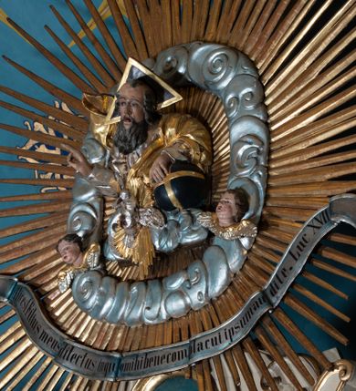 Zdjęcie nr 41: Nastawa ołtarzowa architektoniczna, dwukondygnacyjna, ze zwieńczeniem, pierwsza kondygnacja trójosiowa, druga jednoosiowa, ustawiona na dwustrefowym cokole z wyodrębnionymi, cylindrycznymi fragmentami, z bramkami na osiach bocznych. Ołtarz prostopadłościenny, murowany, z kamienną mensą i kamiennym portatylem. 
Pierwsza kondygnacja wydzielona czterema parami wklęsłych pilastrów o trzonach dekorowanych rocaille'em i zwisami kwiatowymi oraz stojącymi na ich tle dwiema parami kolumn o kapitelach kompozytowych. Podpory dźwigają niepełne belkowanie, przerwane nad polami kondygnacji, obniżone nad zewnętrzną parą kolumn. Na skrajnej partii cokołu nastawy karbowane woluty z fantazyjnymi gruszkowatymi cokołami podtrzymującymi rocaille'owe wazony. W polu środkowym głęboka wnęka w formie stojącego prostokąta zamkniętego łukiem odcinkowym podwójnie nadwieszonym z uskokiem, ujęta profilowaną ramą, z obrazem Ecce Homo w osobnej, podwójnej ramie. Nad nią kartusz rokokowy z napisem „In nomine Jesu / om(n)e Genu flec / tatur. ad Philipenses / Cap(ut) II”. Wnękę flankują figury Matki Boskiej i św. Marii Magdaleny ustawione na rocaille'owych konsolach. Na osiach bocznych figura Dawida i grupa ofiary Izaaka na cokołach z nadlatującymi puttami nad nimi. Druga kondygnacja flankowana trzema parami pilastrów o trzonach przechodzących w spływy wolutowe i osobne woluty, opadające na belkowanie pierwszej kondygnacji, na których siedzą putta i anioły trzymające kartusze z napisami: „ET / GLORIA” i „SOLI / DEO / HONOR”. Kondygnacja zamknięta profilowanym gzymsem wyłamanym na ich osi oraz załamanym w dół nad polem. Na gzymsie fragmenty przerwanego, falistego przyczółka, na których siedzą anioły. W polu obraz św. Macieja w formie zbliżonej do trapezu o dwóch wypukłych bokach, ujęty profilowaną ramą. Pole flankowane akantem, powyżej rocaille'owy kartusz z napisem: „IN / CRUCE / SALUS”. Zwieńczenie w formie zbliżonej do trapezu, o wklęsłych bokach, ujętych wolutami, zamknięte cęgowymi wolutami. W polu obraz Ukrzyżowania w formie zbliżonej do trapezu o dwóch wypukłych bokach, ujęty profilowaną ramą, flankowany akantem. Całość zamknięta płaskorzeźbionym przedstawieniem popiersia Boga Ojca oraz gołębicy Ducha Świętego w glorii, w otoku z obłoków i uskrzydlonych główek anielskich, w glorii promienistej, u dołu szarfa z napisem: „Hic est Filius meus dilectus in quo mihi bene complacui ipsum audite. Luc[a] XVII”. Struktura polichromowana w kolorze beżowym, dolna strefa cokołu brązowa, część trzonów pilastrów pomalowana na kolor jasnoróżowy; trzony kolumn, profile i ornamentyka złocone, detal srebrzony.  


