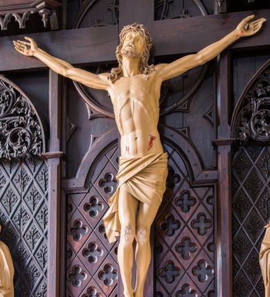 Zdjęcie nr 2: Ołtarz przyścienny, architektoniczny, jednokondygnacyjny. Ołtarz jest prostopadłościenny, z drewnianą mensą. Trójosiowe, artykułowane smukłymi filarkami retabulum osadzone jest na predelli zdobionej fryzem arkadkowym zamknięte rodzajem fryzu przerwanego pośrodku ostrołukową wimpergą. Pole środkowej osi nastawy zajmuje płycina w kształcie stojącego prostokąta zamkniętego półkolistym łukiem nadwieszonym, wypełniona płaskorzeźbionym motywem czwórliści. Wyżej znajduje się dekoracja maswerkowa częściowo wpisana  w okrąg. Osie boczne mają formę płytkich, ostrołukowych wnęk zdobionych motywem kwietnych gałązek wpisanych w romboidalne pola. Partie łuków wypełnia ażurowy ornament astwerkowy. Retabulum ujmuje po bokach para uszaków w formie ażurowych przypór zwieńczonych pinaklami. Fryz zamykający retabulum wieńczy para wyższych pośrodku i niższych po bokach pinakli, natomiast wimpergę niewielki kwiaton. W osi środkowej znajduje się figura Jezusa Ukrzyżowanego, w prawej figura św. Jana Ewangelisty, w lewej Matki Boskiej Bolesnej. 

Struktura ołtarza pokryta jest ciemnobrązową bejcą, figury utrzymane są w odcieniu naturalnego drewna.

