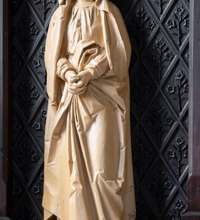 Zdjęcie nr 11: Ołtarz przyścienny, architektoniczny, jednokondygnacyjny. Ołtarz jest prostopadłościenny, z drewnianą mensą. Trójosiowe, artykułowane smukłymi filarkami retabulum osadzone jest na predelli zdobionej fryzem arkadkowym zamknięte rodzajem fryzu przerwanego pośrodku ostrołukową wimpergą. Pole środkowej osi nastawy zajmuje płycina w kształcie stojącego prostokąta zamkniętego półkolistym łukiem nadwieszonym, wypełniona płaskorzeźbionym motywem czwórliści. Wyżej znajduje się dekoracja maswerkowa częściowo wpisana  w okrąg. Osie boczne mają formę płytkich, ostrołukowych wnęk zdobionych motywem kwietnych gałązek wpisanych w romboidalne pola. Partie łuków wypełnia ażurowy ornament astwerkowy. Retabulum ujmuje po bokach para uszaków w formie ażurowych przypór zwieńczonych pinaklami. Fryz zamykający retabulum wieńczy para wyższych pośrodku i niższych po bokach pinakli, natomiast wimpergę niewielki kwiaton. W osi środkowej znajduje się figura Jezusa Ukrzyżowanego, w prawej figura św. Jana Ewangelisty, w lewej Matki Boskiej Bolesnej. 

Struktura ołtarza pokryta jest ciemnobrązową bejcą, figury utrzymane są w odcieniu naturalnego drewna.

