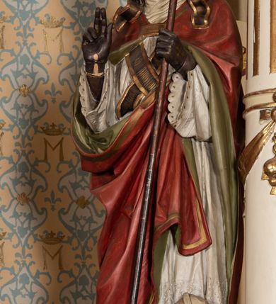 Zdjęcie nr 9: Nastawa ołtarzowa uzyskała charakter jednoosiowej, jednokondygnacyjnej przestrzennej struktury architektonicznej ze zwieńczeniem. Drewniany stipes ołtarzowy przyjął kształt zwężającego się ku dołowi sarkofagu wspierającego mensę, ustawionego na marmurowym podeście o dwu stopniach. Na mensie na osi ustawiono prostopadłościenne tabernakulum na rzucie trapezu, ujęte po bokach spływami wolutowym podtrzymującymi proste belkowanie wyłamane na osi podpór. Drzwiczki do tabernakulum uzyskały kształt stojącego prostokąta zamkniętego u góry łukiem nadwieszonym z uskokiem. W ich polu ukazano kielich z hostią. Retabulum wykonano na rzucie dwóch koncentrycznych półkoli. Pierwsze, tworzy przyścienna struktura flankowana dwoma esowatymi splotami wolutowymi podtrzymującymi architraw z belkowaniem zdobionym fryzem kostkowym, podtrzymującym w osiach skrajnych dwa wolutowe postumenty przechodzące w zwieńczenie. Zwieńczenie utworzono z płyciny w kształcie leżącego prostokąta o wklęsłych bokach zwieńczone gzymsem koronującym wygiętym w formie nadwieszonego łuku odcinkowego. W polu zwieńczenia umieszczono płaskorzeźbiony kartusz z monogramem maryjnym w czerwonym polu flankowany przez dwa uskrzydlone aniołki. Drugie półkole uzyskano z wysunięcia przed lico nastawy dwóch kolumn wspartych na wysokich, dwupoziomowych postumentach oraz flankujących główne pole obrazowe kondygnacji dwóch pilastrów podtrzymujących półkoliście wygięty architraw z belkowaniem, na końcach którego umieszczono przerwane wolutowe przyczółki faliste z siedzącymi na nich dwoma aniołami podtrzymującymi zawieszoną na osi monumentalną koronę zamknietą. Kolumny i pilastry o korynckich kapitelach i głowicach w dwóch trzecich od góry są kanelowane, a niżej gładkie i zdobione wstęgami z zawieszonymi zwisami owocowymi. Podtrzymujące kolumny postumenty ozdobiono niebieskimi, prostokątnymi płycinami u góry zamkniętymi półkoliście, a u dołu wklęsłymi. Po osiach zewnętrznych do postumentów przylegają konsole zdobione akantowymi wolutami, na których ustawiono figury św. Wojciech i św. Stanisława. Architraw drugiego półkola ozdobiono rytmiczne rozmieszczonymi partiami ornamentu roślinnego, a belkowanie i przyczółki faliste fryzem kostkowym. W polu kondygnacji umieszczono pole obrazowe w formie stojącego prostokąta zamkniętego od góry łukiem odcinkowym nadwieszonym obramienionym ramą zdobioną ażurową wicią akantową. W polu znajduje się obraz Matki Boskiej z Dzieciątkiem w rzymskim typie Salus Populi Romani, a na zasuwie obraz przedstawiający wybór św. Macieja na apostoła. Strukturę ołtarza pomalowano w tonacji ciemnej kości słoniowej. Kolumny, profile oraz ornamenty zostały wyzłocone. Rzeźby św. Wojciech i św. Stanisława uzyskały naturalistyczną polichromię podobnie jak anioły podtrzymujące koronę.  