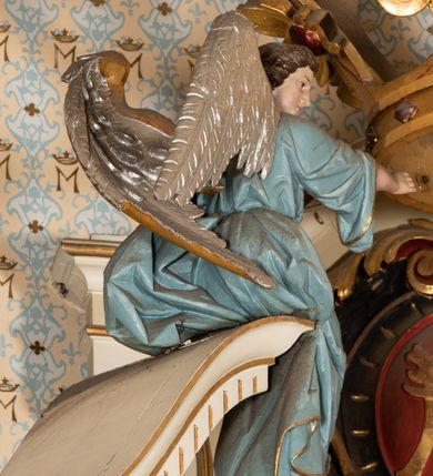 Zdjęcie nr 13: Nastawa ołtarzowa uzyskała charakter jednoosiowej, jednokondygnacyjnej przestrzennej struktury architektonicznej ze zwieńczeniem. Drewniany stipes ołtarzowy przyjął kształt zwężającego się ku dołowi sarkofagu wspierającego mensę, ustawionego na marmurowym podeście o dwu stopniach. Na mensie na osi ustawiono prostopadłościenne tabernakulum na rzucie trapezu, ujęte po bokach spływami wolutowym podtrzymującymi proste belkowanie wyłamane na osi podpór. Drzwiczki do tabernakulum uzyskały kształt stojącego prostokąta zamkniętego u góry łukiem nadwieszonym z uskokiem. W ich polu ukazano kielich z hostią. Retabulum wykonano na rzucie dwóch koncentrycznych półkoli. Pierwsze, tworzy przyścienna struktura flankowana dwoma esowatymi splotami wolutowymi podtrzymującymi architraw z belkowaniem zdobionym fryzem kostkowym, podtrzymującym w osiach skrajnych dwa wolutowe postumenty przechodzące w zwieńczenie. Zwieńczenie utworzono z płyciny w kształcie leżącego prostokąta o wklęsłych bokach zwieńczone gzymsem koronującym wygiętym w formie nadwieszonego łuku odcinkowego. W polu zwieńczenia umieszczono płaskorzeźbiony kartusz z monogramem maryjnym w czerwonym polu flankowany przez dwa uskrzydlone aniołki. Drugie półkole uzyskano z wysunięcia przed lico nastawy dwóch kolumn wspartych na wysokich, dwupoziomowych postumentach oraz flankujących główne pole obrazowe kondygnacji dwóch pilastrów podtrzymujących półkoliście wygięty architraw z belkowaniem, na końcach którego umieszczono przerwane wolutowe przyczółki faliste z siedzącymi na nich dwoma aniołami podtrzymującymi zawieszoną na osi monumentalną koronę zamknietą. Kolumny i pilastry o korynckich kapitelach i głowicach w dwóch trzecich od góry są kanelowane, a niżej gładkie i zdobione wstęgami z zawieszonymi zwisami owocowymi. Podtrzymujące kolumny postumenty ozdobiono niebieskimi, prostokątnymi płycinami u góry zamkniętymi półkoliście, a u dołu wklęsłymi. Po osiach zewnętrznych do postumentów przylegają konsole zdobione akantowymi wolutami, na których ustawiono figury św. Wojciech i św. Stanisława. Architraw drugiego półkola ozdobiono rytmiczne rozmieszczonymi partiami ornamentu roślinnego, a belkowanie i przyczółki faliste fryzem kostkowym. W polu kondygnacji umieszczono pole obrazowe w formie stojącego prostokąta zamkniętego od góry łukiem odcinkowym nadwieszonym obramienionym ramą zdobioną ażurową wicią akantową. W polu znajduje się obraz Matki Boskiej z Dzieciątkiem w rzymskim typie Salus Populi Romani, a na zasuwie obraz przedstawiający wybór św. Macieja na apostoła. Strukturę ołtarza pomalowano w tonacji ciemnej kości słoniowej. Kolumny, profile oraz ornamenty zostały wyzłocone. Rzeźby św. Wojciech i św. Stanisława uzyskały naturalistyczną polichromię podobnie jak anioły podtrzymujące koronę.  