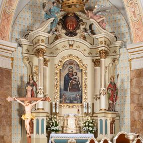 Zdjęcie nr 1: Nastawa ołtarzowa uzyskała charakter jednoosiowej, jednokondygnacyjnej przestrzennej struktury architektonicznej ze zwieńczeniem. Drewniany stipes ołtarzowy przyjął kształt zwężającego się ku dołowi sarkofagu wspierającego mensę, ustawionego na marmurowym podeście o dwu stopniach. Na mensie na osi ustawiono prostopadłościenne tabernakulum na rzucie trapezu, ujęte po bokach spływami wolutowym podtrzymującymi proste belkowanie wyłamane na osi podpór. Drzwiczki do tabernakulum uzyskały kształt stojącego prostokąta zamkniętego u góry łukiem nadwieszonym z uskokiem. W ich polu ukazano kielich z hostią. Retabulum wykonano na rzucie dwóch koncentrycznych półkoli. Pierwsze, tworzy przyścienna struktura flankowana dwoma esowatymi splotami wolutowymi podtrzymującymi architraw z belkowaniem zdobionym fryzem kostkowym, podtrzymującym w osiach skrajnych dwa wolutowe postumenty przechodzące w zwieńczenie. Zwieńczenie utworzono z płyciny w kształcie leżącego prostokąta o wklęsłych bokach zwieńczone gzymsem koronującym wygiętym w formie nadwieszonego łuku odcinkowego. W polu zwieńczenia umieszczono płaskorzeźbiony kartusz z monogramem maryjnym w czerwonym polu flankowany przez dwa uskrzydlone aniołki. Drugie półkole uzyskano z wysunięcia przed lico nastawy dwóch kolumn wspartych na wysokich, dwupoziomowych postumentach oraz flankujących główne pole obrazowe kondygnacji dwóch pilastrów podtrzymujących półkoliście wygięty architraw z belkowaniem, na końcach którego umieszczono przerwane wolutowe przyczółki faliste z siedzącymi na nich dwoma aniołami podtrzymującymi zawieszoną na osi monumentalną koronę zamknietą. Kolumny i pilastry o korynckich kapitelach i głowicach w dwóch trzecich od góry są kanelowane, a niżej gładkie i zdobione wstęgami z zawieszonymi zwisami owocowymi. Podtrzymujące kolumny postumenty ozdobiono niebieskimi, prostokątnymi płycinami u góry zamkniętymi półkoliście, a u dołu wklęsłymi. Po osiach zewnętrznych do postumentów przylegają konsole zdobione akantowymi wolutami, na których ustawiono figury św. Wojciech i św. Stanisława. Architraw drugiego półkola ozdobiono rytmiczne rozmieszczonymi partiami ornamentu roślinnego, a belkowanie i przyczółki faliste fryzem kostkowym. W polu kondygnacji umieszczono pole obrazowe w formie stojącego prostokąta zamkniętego od góry łukiem odcinkowym nadwieszonym obramienionym ramą zdobioną ażurową wicią akantową. W polu znajduje się obraz Matki Boskiej z Dzieciątkiem w rzymskim typie Salus Populi Romani, a na zasuwie obraz przedstawiający wybór św. Macieja na apostoła. Strukturę ołtarza pomalowano w tonacji ciemnej kości słoniowej. Kolumny, profile oraz ornamenty zostały wyzłocone. Rzeźby św. Wojciech i św. Stanisława uzyskały naturalistyczną polichromię podobnie jak anioły podtrzymujące koronę.  