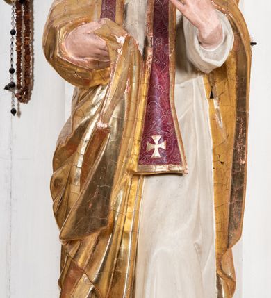 Zdjęcie nr 8: Nastawa ołtarzowa uzyskała charakter przyściennego retabulum jednoosiowego, jednokondygnacyjnego ze zwieńczeniem. Drewniany stipes ołtarzowy przyjął kształt zwężającego się ku dołowi sarkofagu ustawionego na jednostopniowym podeście. Na mensie na osi ustawiono prostopadłościenne tabernakulum obite blachą w formie skrzynki. Drzwiczki do tabernakulum ozdobiono puncowanym krzyżem. Kondygnację nastawy ujmują dwa filary o trzonach zdobionych u góry wolutowymi konsolami i zawieszonymi na taśmie girlandami roślinno-kwiatowymi oraz dwie smukłe kolumny z kapitelami korynckimi, wsparte na wklęsło-wypukłym cokole przerwanym na szerokość pola obrazowego na osi. Cokół artykułują płyciny dekorowane czworobocznym ornamentem roślinnym. Na tle filarów ustawiono rzeźby św. Stanisława Kostki oraz św. Dominika. Pomiędzy filarami widoczne jest prostokątne pole obrazowe ujęte profilowaną ramą, w której umieszczono obraz Niepokalanego Poczęcia. Podpory dźwigają wklęsło-wypukłe belkowanie ustawione na wysokim architrawie dekorowanym czworobocznym ornamentem roślinnym. W osiach skrajnych na belkowaniu umieszczono dwie figury siedzących aniołów. Zwieńczenie nastawy uzyskało kształt leżącego prostokąta o wklęsłych bokach przechodzących w spływy wolutowe, podtrzymujących gzyms koronujący w formie nadwieszonego łuku odcinkowego z krzyżem pośrodku. W polu zwieńczenia umieszczono owalny obraz w profilowanej ramie z przedstawieniem św. Karola Boromeusza. Strukturę ołtarza pomalowano w tonacji jasnobeżowej. Kolumny, profile, ornamenty oraz szaty postaci zostały wyzłocone, a skrzydła aniołów wysrebrzone. Figury w partii ciała otrzymały naturalistyczną polichromię.