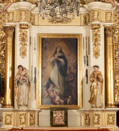 Zdjęcie nr 1: Nastawa ołtarzowa uzyskała charakter przyściennego retabulum jednoosiowego, jednokondygnacyjnego ze zwieńczeniem. Drewniany stipes ołtarzowy przyjął kształt zwężającego się ku dołowi sarkofagu ustawionego na jednostopniowym podeście. Na mensie na osi ustawiono prostopadłościenne tabernakulum obite blachą w formie skrzynki. Drzwiczki do tabernakulum ozdobiono puncowanym krzyżem. Kondygnację nastawy ujmują dwa filary o trzonach zdobionych u góry wolutowymi konsolami i zawieszonymi na taśmie girlandami roślinno-kwiatowymi oraz dwie smukłe kolumny z kapitelami korynckimi, wsparte na wklęsło-wypukłym cokole przerwanym na szerokość pola obrazowego na osi. Cokół artykułują płyciny dekorowane czworobocznym ornamentem roślinnym. Na tle filarów ustawiono rzeźby św. Stanisława Kostki oraz św. Dominika. Pomiędzy filarami widoczne jest prostokątne pole obrazowe ujęte profilowaną ramą, w której umieszczono obraz Niepokalanego Poczęcia. Podpory dźwigają wklęsło-wypukłe belkowanie ustawione na wysokim architrawie dekorowanym czworobocznym ornamentem roślinnym. W osiach skrajnych na belkowaniu umieszczono dwie figury siedzących aniołów. Zwieńczenie nastawy uzyskało kształt leżącego prostokąta o wklęsłych bokach przechodzących w spływy wolutowe, podtrzymujących gzyms koronujący w formie nadwieszonego łuku odcinkowego z krzyżem pośrodku. W polu zwieńczenia umieszczono owalny obraz w profilowanej ramie z przedstawieniem św. Karola Boromeusza. Strukturę ołtarza pomalowano w tonacji jasnobeżowej. Kolumny, profile, ornamenty oraz szaty postaci zostały wyzłocone, a skrzydła aniołów wysrebrzone. Figury w partii ciała otrzymały naturalistyczną polichromię.