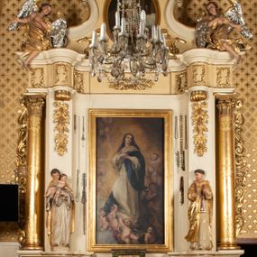 Zdjęcie nr 1: Nastawa ołtarzowa uzyskała charakter przyściennego retabulum jednoosiowego, jednokondygnacyjnego ze zwieńczeniem. Drewniany stipes ołtarzowy przyjął kształt zwężającego się ku dołowi sarkofagu ustawionego na jednostopniowym podeście. Na mensie na osi ustawiono prostopadłościenne tabernakulum obite blachą w formie skrzynki. Drzwiczki do tabernakulum ozdobiono puncowanym krzyżem. Kondygnację nastawy ujmują dwa filary o trzonach zdobionych u góry wolutowymi konsolami i zawieszonymi na taśmie girlandami roślinno-kwiatowymi oraz dwie smukłe kolumny z kapitelami korynckimi, wsparte na wklęsło-wypukłym cokole przerwanym na szerokość pola obrazowego na osi. Cokół artykułują płyciny dekorowane czworobocznym ornamentem roślinnym. Na tle filarów ustawiono rzeźby św. Stanisława Kostki oraz św. Dominika. Pomiędzy filarami widoczne jest prostokątne pole obrazowe ujęte profilowaną ramą, w której umieszczono obraz Niepokalanego Poczęcia. Podpory dźwigają wklęsło-wypukłe belkowanie ustawione na wysokim architrawie dekorowanym czworobocznym ornamentem roślinnym. W osiach skrajnych na belkowaniu umieszczono dwie figury siedzących aniołów. Zwieńczenie nastawy uzyskało kształt leżącego prostokąta o wklęsłych bokach przechodzących w spływy wolutowe, podtrzymujących gzyms koronujący w formie nadwieszonego łuku odcinkowego z krzyżem pośrodku. W polu zwieńczenia umieszczono owalny obraz w profilowanej ramie z przedstawieniem św. Karola Boromeusza. Strukturę ołtarza pomalowano w tonacji jasnobeżowej. Kolumny, profile, ornamenty oraz szaty postaci zostały wyzłocone, a skrzydła aniołów wysrebrzone. Figury w partii ciała otrzymały naturalistyczną polichromię.