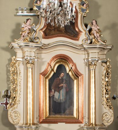 Zdjęcie nr 2: Nastawa ołtarzowa architektoniczna, jednoosiowa, jednokondygnacyjna ze zwieńczeniem. Ołtarz sarkofagowy, wklęsło-wypukły, na cokole, z mensą. Nastawa ujęta parą kolumn o kapitelach kompozytowych, ustawionych na cokołach, dźwigających belkowanie o falistej linii, wyłamane na ich osi, z przerwanym architrawem nad polem środkowym. Na belkowaniu fragmenty przerwanego, falistego przyczółka, dekorowanego rocaille'em, z siedzącymi puttami. Kondygnacja flankowana spływami wolutowymi zdobionymi rocaille'em, opadającymi na cokoły oraz uszami utworzonymi z esowato skręconego akantu. W polu środkowym wnęka w formie stojącego prostokąta zamkniętego łukiem półkolistym nadwieszonym z uskokiem, ujęta profilowaną ramą, z obrazem przedstawiającym św. Jana Nepomucena, w osobnej ramie. Zwieńczenie w formie zbliżonej do trapezu zamkniętego falistym fragmentem gzymsu, flankowane spływami wolutowymi dekorowanymi karbowaną wstęgą oraz rokokowymi kartuszami z uskrzydlonymi główkami anielskimi. W polu obraz św. Wojciecha w formie zbliżonej do trapezu o falistej linii boków, ujęty profilowaną ramą. Całość zakończona medalionem z okiem Opatrzności, w otoku z obłoków, w glorii promienistej. Struktura polichromowana w kolorze beżowym, ze złoconymi kolumnami, ornamentyką i profilami, srebrzonymi detalami i laserowanymi ramami obrazów. 
