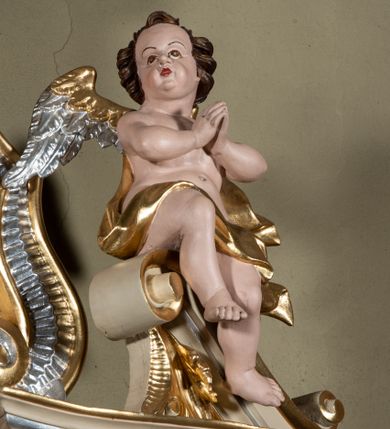 Zdjęcie nr 4: Nastawa ołtarzowa architektoniczna, jednoosiowa, jednokondygnacyjna ze zwieńczeniem. Ołtarz sarkofagowy, wklęsło-wypukły, na cokole, z mensą. Nastawa ujęta parą kolumn o kapitelach kompozytowych, ustawionych na cokołach, dźwigających belkowanie o falistej linii, wyłamane na ich osi, z przerwanym architrawem nad polem środkowym. Na belkowaniu fragmenty przerwanego, falistego przyczółka, dekorowanego rocaille'em, z siedzącymi puttami. Kondygnacja flankowana spływami wolutowymi zdobionymi rocaille'em, opadającymi na cokoły oraz uszami utworzonymi z esowato skręconego akantu. W polu środkowym wnęka w formie stojącego prostokąta zamkniętego łukiem półkolistym nadwieszonym z uskokiem, ujęta profilowaną ramą, z obrazem przedstawiającym św. Jana Nepomucena, w osobnej ramie. Zwieńczenie w formie zbliżonej do trapezu zamkniętego falistym fragmentem gzymsu, flankowane spływami wolutowymi dekorowanymi karbowaną wstęgą oraz rokokowymi kartuszami z uskrzydlonymi główkami anielskimi. W polu obraz św. Wojciecha w formie zbliżonej do trapezu o falistej linii boków, ujęty profilowaną ramą. Całość zakończona medalionem z okiem Opatrzności, w otoku z obłoków, w glorii promienistej. Struktura polichromowana w kolorze beżowym, ze złoconymi kolumnami, ornamentyką i profilami, srebrzonymi detalami i laserowanymi ramami obrazów. 
