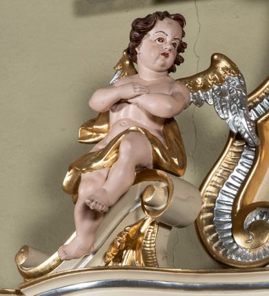 Zdjęcie nr 3: Nastawa ołtarzowa architektoniczna, jednoosiowa, jednokondygnacyjna ze zwieńczeniem. Ołtarz sarkofagowy, wklęsło-wypukły, na cokole, z mensą. Nastawa ujęta parą kolumn o kapitelach kompozytowych, ustawionych na cokołach, dźwigających belkowanie o falistej linii, wyłamane na ich osi, z przerwanym architrawem nad polem środkowym. Na belkowaniu fragmenty przerwanego, falistego przyczółka, dekorowanego rocaille'em, z siedzącymi puttami. Kondygnacja flankowana spływami wolutowymi zdobionymi rocaille'em, opadającymi na cokoły oraz uszami utworzonymi z esowato skręconego akantu. W polu środkowym wnęka w formie stojącego prostokąta zamkniętego łukiem półkolistym nadwieszonym z uskokiem, ujęta profilowaną ramą, z obrazem przedstawiającym św. Jana Nepomucena, w osobnej ramie. Zwieńczenie w formie zbliżonej do trapezu zamkniętego falistym fragmentem gzymsu, flankowane spływami wolutowymi dekorowanymi karbowaną wstęgą oraz rokokowymi kartuszami z uskrzydlonymi główkami anielskimi. W polu obraz św. Wojciecha w formie zbliżonej do trapezu o falistej linii boków, ujęty profilowaną ramą. Całość zakończona medalionem z okiem Opatrzności, w otoku z obłoków, w glorii promienistej. Struktura polichromowana w kolorze beżowym, ze złoconymi kolumnami, ornamentyką i profilami, srebrzonymi detalami i laserowanymi ramami obrazów. 
