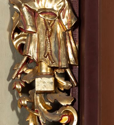 Zdjęcie nr 3: Ołtarz architektoniczny, jednoosiowy, jednokondygnacyjny ze zwieńczeniem. Retabulum osadzone jest na wysokim, zdwojonym, zryzalitowanym uskokowo cokole. Ołtarz jest prostopadłościenny z drewnianą mensą. Część środkową ujmuje para kolumn o żłobkowanych trzonach i korynckich kapitelach, ustawionych na tle zdwojonych pilastrów. Podpory dźwigają wyłamujące się ponad nimi belkowanie o silnie wysuniętym gzymsie. Zwieńczenie ma formę aediculi ujętej parą pilastrów i spływów wolutowych, zamkniętej trójkątnym przyczółkiem. Dodatkowo ujęta jest ona przerwanym, półkolistym przyczółkiem. Płycina antepedium jest w kształcie leżącego prostokąta z płaskorzeźbionym motywem złoconego kielicha eucharystycznego oraz kwiatów lilii skrzyżowanych z włócznią oraz trzciną z gąbką na tle srebrzonych obłoków ujętych promienistą glorią. Płyciny górnego cokołu (predelli) zdobi motyw ostów i cierni. Część środkową ujmuje para ażurowych, akantowych uszaków z motywem tuniki, kolumny biczowania oraz trzciny po lewej stronie i chusty św. Weroniki, drabiny, włóczni i trzciny z gąbką po prawej. U góry, pośrodku znajduje się uskrzydlona główka anielska. Powyżej, w partii belkowania, którego gzyms zdobi kostkowanie, jest umieszczony kartusz herbowy z monogramem IHS. Fryz zdobi stylizowana wić roślinna oraz para uskrzydlonych główek anielskich, natomiast zwieńczenie retabulum m.in. motywy roślinne, rozetki i kampanulle. Szczyt tworzy podtrzymująca krzyż para aniołów o sylwetkach od pasa w dół w formie liści akantu. Na przerwanym przyczółku znajduje się para przyklękających aniołów, ubranych w suknie w kolorach jasnoczerwonym i niebieskim oraz złocone płaszcze, trzymających w dłoniach włócznię i trzcinę z gąbką. Pole w części środkowej ma kształt stojącego prostokąta ujętego profilowaną, złoconą ramą. W środku znajduje się przedstawienie św. Anny nauczającej małą Marię. Pole w zwieńczeniu ma kształt stojącego owalu ujętego złoconą ramą w formie wieńca laurowego. Zawiera wizerunek św. Józefa. 
Struktura retabulum utrzymana jest w odcieniach brązu, partie detalu architektonicznego i ornamentyka są złocone.      
