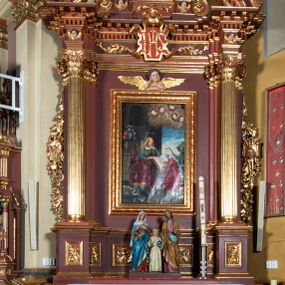 Zdjęcie nr 1: Ołtarz architektoniczny, jednoosiowy, jednokondygnacyjny ze zwieńczeniem. Retabulum osadzone jest na wysokim, zdwojonym, zryzalitowanym uskokowo cokole. Ołtarz jest prostopadłościenny z drewnianą mensą. Część środkową ujmuje para kolumn o żłobkowanych trzonach i korynckich kapitelach, ustawionych na tle zdwojonych pilastrów. Podpory dźwigają wyłamujące się ponad nimi belkowanie o silnie wysuniętym gzymsie. Zwieńczenie ma formę aediculi ujętej parą pilastrów i spływów wolutowych, zamkniętej trójkątnym przyczółkiem. Dodatkowo ujęta jest ona przerwanym, półkolistym przyczółkiem. Płycina antepedium jest w kształcie leżącego prostokąta z płaskorzeźbionym motywem złoconego kielicha eucharystycznego oraz kwiatów lilii skrzyżowanych z włócznią oraz trzciną z gąbką na tle srebrzonych obłoków ujętych promienistą glorią. Płyciny górnego cokołu (predelli) zdobi motyw ostów i cierni. Część środkową ujmuje para ażurowych, akantowych uszaków z motywem tuniki, kolumny biczowania oraz trzciny po lewej stronie i chusty św. Weroniki, drabiny, włóczni i trzciny z gąbką po prawej. U góry, pośrodku znajduje się uskrzydlona główka anielska. Powyżej, w partii belkowania, którego gzyms zdobi kostkowanie, jest umieszczony kartusz herbowy z monogramem IHS. Fryz zdobi stylizowana wić roślinna oraz para uskrzydlonych główek anielskich, natomiast zwieńczenie retabulum m.in. motywy roślinne, rozetki i kampanulle. Szczyt tworzy podtrzymująca krzyż para aniołów o sylwetkach od pasa w dół w formie liści akantu. Na przerwanym przyczółku znajduje się para przyklękających aniołów, ubranych w suknie w kolorach jasnoczerwonym i niebieskim oraz złocone płaszcze, trzymających w dłoniach włócznię i trzcinę z gąbką. Pole w części środkowej ma kształt stojącego prostokąta ujętego profilowaną, złoconą ramą. W środku znajduje się przedstawienie św. Anny nauczającej małą Marię. Pole w zwieńczeniu ma kształt stojącego owalu ujętego złoconą ramą w formie wieńca laurowego. Zawiera wizerunek św. Józefa. 
Struktura retabulum utrzymana jest w odcieniach brązu, partie detalu architektonicznego i ornamentyka są złocone.      
