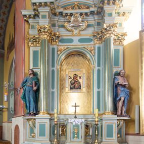 Zdjęcie nr 1: Ołtarz przyścienny, prostopadłościenny, z antepedium, na którym umieszczony jest rzeźbiony monogram Marii; mensa drewniana z kamiennym portatylem. Na mensie znajduje się tabernakulum o kształcie graniastosłupa, z drzwiczkami ozdobionymi rzeźbionym kielichem z hostią. Nastawa ołtarzowa jest architektoniczna, jednoosiowa, jednokondygnacyjna ze zwieńczeniem. Osadzona na podwójnym postumencie, flankowana pilastrami o kompozytowych kapitelach i kanelowanymi kolumnami o kompozytowych kapitelach, które podtrzymują belkowanie. Ponad belkowaniem znajduje się przełamany przyczółek w formie łuku półkolistego, bogato profilowany, ozdobiony ulistnionymi konsolkami i rozetami oraz girlandami z owoców. W partii fryzu kartusz o fantazyjnym wykroju, ujęty wolutami i listkami akantu. Na belkowaniu siedzą po bokach putta, odziane tkaniną na biodrach, a pośrodku znajduje się krzyż osadzony na postumencie z liśćmi. Po obu stronach ołtarza na konsolach o krawędziach ozdobionych ornamentem małżowinowym stoją figury trudnych do identyfikacji świętych, być może apostołów. W centralnej części ołtarza wnęka prostokątna, zamknięta łukiem półkolistym, wypełniona złoconą blachą z rytą ukośną kratką wypełnioną rozetkami. Na blasze zawieszony obraz z przedstawieniem Matki Boskiej Nieustającej Pomocy, który ujęty jest w prostokątną, blaszaną ramę. 

