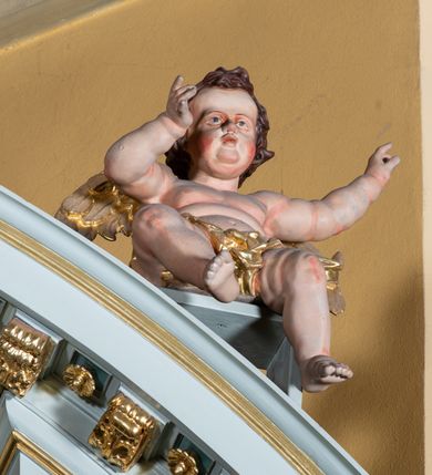 Zdjęcie nr 24: Ołtarz przyścienny, prostopadłościenny, z antepedium, na którym umieszczony jest rzeźbiony monogram Marii; mensa drewniana z kamiennym portatylem. Na mensie znajduje się tabernakulum o kształcie graniastosłupa, z drzwiczkami ozdobionymi rzeźbionym kielichem z hostią. Nastawa ołtarzowa jest architektoniczna, jednoosiowa, jednokondygnacyjna ze zwieńczeniem. Osadzona na podwójnym postumencie, flankowana pilastrami o kompozytowych kapitelach i kanelowanymi kolumnami o kompozytowych kapitelach, które podtrzymują belkowanie. Ponad belkowaniem znajduje się przełamany przyczółek w formie łuku półkolistego, bogato profilowany, ozdobiony ulistnionymi konsolkami i rozetami oraz girlandami z owoców. W partii fryzu kartusz o fantazyjnym wykroju, ujęty wolutami i listkami akantu. Na belkowaniu siedzą po bokach putta, odziane tkaniną na biodrach, a pośrodku znajduje się krzyż osadzony na postumencie z liśćmi. Po obu stronach ołtarza na konsolach o krawędziach ozdobionych ornamentem małżowinowym stoją figury trudnych do identyfikacji świętych, być może apostołów. W centralnej części ołtarza wnęka prostokątna, zamknięta łukiem półkolistym, wypełniona złoconą blachą z rytą ukośną kratką wypełnioną rozetkami. Na blasze zawieszony obraz z przedstawieniem Matki Boskiej Nieustającej Pomocy, który ujęty jest w prostokątną, blaszaną ramę. 

