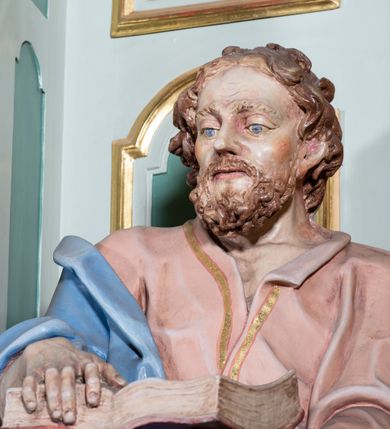 Zdjęcie nr 16: Ołtarz przyścienny, prostopadłościenny, z antepedium, na którym umieszczony jest rzeźbiony monogram Marii; mensa drewniana z kamiennym portatylem. Na mensie znajduje się tabernakulum o kształcie graniastosłupa, z drzwiczkami ozdobionymi rzeźbionym kielichem z hostią. Nastawa ołtarzowa jest architektoniczna, jednoosiowa, jednokondygnacyjna ze zwieńczeniem. Osadzona na podwójnym postumencie, flankowana pilastrami o kompozytowych kapitelach i kanelowanymi kolumnami o kompozytowych kapitelach, które podtrzymują belkowanie. Ponad belkowaniem znajduje się przełamany przyczółek w formie łuku półkolistego, bogato profilowany, ozdobiony ulistnionymi konsolkami i rozetami oraz girlandami z owoców. W partii fryzu kartusz o fantazyjnym wykroju, ujęty wolutami i listkami akantu. Na belkowaniu siedzą po bokach putta, odziane tkaniną na biodrach, a pośrodku znajduje się krzyż osadzony na postumencie z liśćmi. Po obu stronach ołtarza na konsolach o krawędziach ozdobionych ornamentem małżowinowym stoją figury trudnych do identyfikacji świętych, być może apostołów. W centralnej części ołtarza wnęka prostokątna, zamknięta łukiem półkolistym, wypełniona złoconą blachą z rytą ukośną kratką wypełnioną rozetkami. Na blasze zawieszony obraz z przedstawieniem Matki Boskiej Nieustającej Pomocy, który ujęty jest w prostokątną, blaszaną ramę. 

