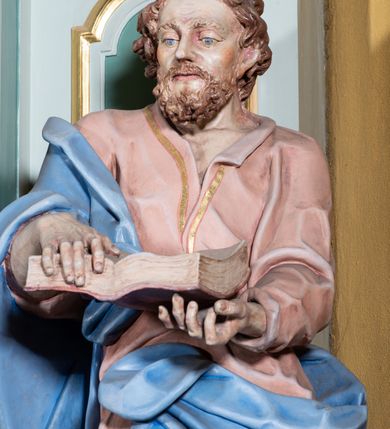 Zdjęcie nr 15: Ołtarz przyścienny, prostopadłościenny, z antepedium, na którym umieszczony jest rzeźbiony monogram Marii; mensa drewniana z kamiennym portatylem. Na mensie znajduje się tabernakulum o kształcie graniastosłupa, z drzwiczkami ozdobionymi rzeźbionym kielichem z hostią. Nastawa ołtarzowa jest architektoniczna, jednoosiowa, jednokondygnacyjna ze zwieńczeniem. Osadzona na podwójnym postumencie, flankowana pilastrami o kompozytowych kapitelach i kanelowanymi kolumnami o kompozytowych kapitelach, które podtrzymują belkowanie. Ponad belkowaniem znajduje się przełamany przyczółek w formie łuku półkolistego, bogato profilowany, ozdobiony ulistnionymi konsolkami i rozetami oraz girlandami z owoców. W partii fryzu kartusz o fantazyjnym wykroju, ujęty wolutami i listkami akantu. Na belkowaniu siedzą po bokach putta, odziane tkaniną na biodrach, a pośrodku znajduje się krzyż osadzony na postumencie z liśćmi. Po obu stronach ołtarza na konsolach o krawędziach ozdobionych ornamentem małżowinowym stoją figury trudnych do identyfikacji świętych, być może apostołów. W centralnej części ołtarza wnęka prostokątna, zamknięta łukiem półkolistym, wypełniona złoconą blachą z rytą ukośną kratką wypełnioną rozetkami. Na blasze zawieszony obraz z przedstawieniem Matki Boskiej Nieustającej Pomocy, który ujęty jest w prostokątną, blaszaną ramę. 

