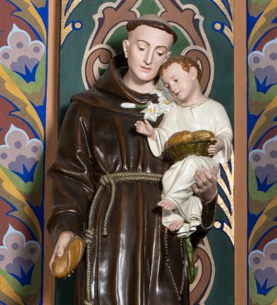 Zdjęcie nr 1: Rzeźba pełna, ustawiona na niskiej, profilowanej podstawie. Święty ukazany frontalnie, z ugiętą lewą nogą, pochyloną głową, w prawej opuszczonej w dół ręce trzyma bochenek chleba, lewą podtrzymuje Dzieciątko i przytrzymuje gałązkę lilii. Twarz ma szczupłą, o migdałowatych oczach skierowanych w dół, prostym, wąskim nosie i ustach. Włosy ma krótkie, brązowe, na głowie tonsura. Ubrany jest w ciemnobrązowy habit z kapturem, przewiązany w pasie podwójnym sznurem. Przy lewym boku ma zawieszony różaniec. Dzieciątko w pozycji siedzącej, z pochyloną głową, prawą rączkę unosi w geście błogosławieństwa, lewą przytrzymuje leżący na jego kolanach koszyk z bochenkami chleba. Twarz ma szczupłą, o wąskich oczach, małym nosie i ustach; okoloną krótkimi, brązowymi włosami. Ubrane jest w białą, luźną tunikę ze złoconą lamówką. Polichromia ciała figur naturalistyczna. 

