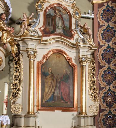 Zdjęcie nr 7: Nastawa ołtarzowa architektoniczna, jednoosiowa, jednokondygnacyjna ze zwieńczeniem. Ołtarz sarkofagowy, wklęsło-wypukły, na cokole, z mensą. Nastawa ujęta parą kolumn o kapitelach kompozytowych, ustawionych na cokołach, dźwigających belkowanie o falistej linii, wyłamane na ich osi, z przerwanym architrawem nad polem środkowym. Na belkowaniu fragmenty przerwanego, falistego przyczółka, dekorowanego rocaille'em, z siedzącymi puttami. Kondygnacja flankowana spływami wolutowymi zdobionymi rocaille'em, opadającymi na cokoły oraz uszami utworzonymi z esowato skręconego akantu. W polu środkowym wnęka w formie stojącego prostokąta zamkniętego łukiem półkolistym nadwieszonym z uskokiem, ujęta profilowaną ramą, z obrazem przedstawiającym św. Piotra i św. Pawła. Zwieńczenie w formie zbliżonej do trapezu, zamkniętego falistym fragmentem gzymsu, flankowane spływami wolutowymi dekorowanymi karbowaną wstęgą oraz rokokowymi kartuszami. W polu obraz św. Heleny w formie zbliżonej do trapezu o falistej linii boków, ujęty profilowaną ramą. Całość zakończona medalionem z monogramem IHS, w otoku z obłoków i dwóch uskrzydlonych główek anielskich, w glorii promienistej. Struktura polichromowana w kolorze beżowym, ze złoconymi kolumnami, ornamentyką i profilami, srebrzonymi detalami i laserowanymi ramami obrazów. 
