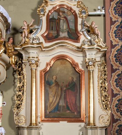 Zdjęcie nr 9: Nastawa ołtarzowa architektoniczna, jednoosiowa, jednokondygnacyjna ze zwieńczeniem. Ołtarz sarkofagowy, wklęsło-wypukły, na cokole, z mensą. Nastawa ujęta parą kolumn o kapitelach kompozytowych, ustawionych na cokołach, dźwigających belkowanie o falistej linii, wyłamane na ich osi, z przerwanym architrawem nad polem środkowym. Na belkowaniu fragmenty przerwanego, falistego przyczółka, dekorowanego rocaille'em, z siedzącymi puttami. Kondygnacja flankowana spływami wolutowymi zdobionymi rocaille'em, opadającymi na cokoły oraz uszami utworzonymi z esowato skręconego akantu. W polu środkowym wnęka w formie stojącego prostokąta zamkniętego łukiem półkolistym nadwieszonym z uskokiem, ujęta profilowaną ramą, z obrazem przedstawiającym św. Piotra i św. Pawła. Zwieńczenie w formie zbliżonej do trapezu, zamkniętego falistym fragmentem gzymsu, flankowane spływami wolutowymi dekorowanymi karbowaną wstęgą oraz rokokowymi kartuszami. W polu obraz św. Heleny w formie zbliżonej do trapezu o falistej linii boków, ujęty profilowaną ramą. Całość zakończona medalionem z monogramem IHS, w otoku z obłoków i dwóch uskrzydlonych główek anielskich, w glorii promienistej. Struktura polichromowana w kolorze beżowym, ze złoconymi kolumnami, ornamentyką i profilami, srebrzonymi detalami i laserowanymi ramami obrazów. 
