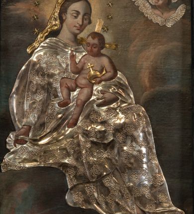 Zdjęcie nr 2: Obraz w formie stojącego prostokąta. W centrum na obłokach siedzi Maria, zwrócona w trzech czwartych w lewo, lewą ręką podtrzymuje Dzieciątko, w prawej, wyciągniętej w bok trzyma fragment płaszcza. Stopy opiera na sierpie księżyca, przesłoniętym metalowym, wokół którego wije się wąż. Maria ma owalną twarz, z wysokim czołem, o dużych, okrągłych oczach skierowanych w dół, dużym nosie i małych, pełnych ustach; okoloną długimi, brązowymi włosami. Wokół głowy ma wieniec z aplikowanych, metalowych gwiazd. Ubrana jest w strój przesłonięty metalową, srebrzoną sukienką w postaci sukni o kwiatowym wzorze, przepasaną w talii, na plecy ma narzucony płaszcz, zawinięty na jej lewym ramieniu, na którym siedzi Dzieciątko. Na głowie ma welon przesłonięty metalowym, złoconym. Jezus w pozycji siedzącej, zwrócony w trzech czwartych w prawo, w lewej dłoni trzyma jabłko królewskie, przesłonięte metalowym, złoconym, prawą unosi w geście błogosławieństwa. Twarz ma owalną, o okrągłych oczach skierowanych w dół, małym nosie i pełnych ustach, okoloną krótkimi, jasnobrązowymi włosami. Ciało ma nagie, pulchne. Od jego głowy odchodzą trzy wiązki aplikowanych, metalowych i złoconych promieni. Postacie ukazane są na tle gęstych, szaro-różowych obłoków, rozświetlonych na żółto w górnej części obrazu, wokół głowy Marii. W prawym górnym rogu dwie uskrzydlone główki anielskie z aplikowanmi metalowymi i srebrzonymi skrzydłami. 