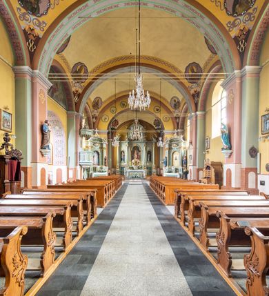 Zdjęcie nr 3: Orientowany kościół św. Urbana w Brzeszczach został wzniesiony w układzie czteroprzęsłowej nawy z prostokątnie zamkniętym prezbiterium, na przedłużeniu którego wzniesiono mniejszą, dwupiętrową zakrystię na rzucie prostokąta. Od północy i od południa do nawy dobudowano po jednej kaplicy, łącząc kaplicę południową z dawną zakrystią. Od zachodu do do nawy dostawiono masyw wieżowy z nieznacznie wysuniętą do przodu czworoboczną wieżę, flankowaną po bokach dwoma aneksami tej samej wysokości, co nawa. Kościół oraz dobudowane kaplice i zakrystia zostały przykryte miedzianymi dachami siodłowymi. Przy końcu nawy od wschodu na dachu nadwieszono wieżyczkę na sygnaturkę w formie latarni zwieńczonej baniastym hełmem. Podobną, bardziej przysadzistą wieżyczkę umieszczono na dachu kaplicy północnej. Elewacje zewnętrzne przeprute półokrągłymi oknami artykułowano za pomocą pilastrów o prostych głowicach wspartych na wysoki cokołach połączonych ze sobą gzymsem, podtrzymujących fazowane belkowanie przechodzące w profilowany gzyms koronujący. Elewacje wieży podzielona na dwie strefy rozdzielone belkowaniem wyłamanym w partii masywu wieżowego. Górna część wieży uzyskała ścięte naroża. W dolnej strefie w przyziemiu urządzono kruchtę, do której wejście na osi flankowane jest masywnym portalem utworzonym z dwóch czworobocznych podpór wspierających trójkątny przyczółek, ponad którym przepruto półokrągłe okno. Ponad gzymsem, w górnej strefie, zastosowano podział ramowy, ujmujący okulus, który pełni partię cokołową wspierającą flankujące górną część wieży pary pilastrów na każdej z czterech elewacji. Pilastry ustawione na postumentach o gładkich trzonach i kompozytowych głowicach wspierają fazowane belkowanie przechodzące w gzyms koronujący. Pomiędzy pilastrami przepruto półokrągłe okna z umieszczonymi nad nimi odcinkami belkowania. Ponad nimi zamontowano tarcze zegarowe. Wieżę zwieńczono baniastym hełmem z sześcioboczną latarnią nakrytą ostrosłupowym zwieńczeniem z krzyżem. Nawa główna otwiera się do kaplic bocznych za pomocą arkady. Wnętrze nakryto sklepieniem żaglastym. Całe wnętrze obiega marmurowa okładzina w formie boazerii. Chór muzyczny z prospektem organowym zajmuje całą szerokość nawy, wspierając się na dwóch filarach połączonych arkadą. Prosta balustrada chóru nad arkadą jest nieznacznie wypukła. W prezbiterium ustawiono ołtarz główny, a w kaplicach ołtarze boczne. Na ścianie północnej nawy przy prezbiterium zawieszono ambonę. 