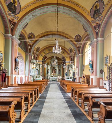 Zdjęcie nr 4: Orientowany kościół św. Urbana w Brzeszczach został wzniesiony w układzie czteroprzęsłowej nawy z prostokątnie zamkniętym prezbiterium, na przedłużeniu którego wzniesiono mniejszą, dwupiętrową zakrystię na rzucie prostokąta. Od północy i od południa do nawy dobudowano po jednej kaplicy, łącząc kaplicę południową z dawną zakrystią. Od zachodu do do nawy dostawiono masyw wieżowy z nieznacznie wysuniętą do przodu czworoboczną wieżę, flankowaną po bokach dwoma aneksami tej samej wysokości, co nawa. Kościół oraz dobudowane kaplice i zakrystia zostały przykryte miedzianymi dachami siodłowymi. Przy końcu nawy od wschodu na dachu nadwieszono wieżyczkę na sygnaturkę w formie latarni zwieńczonej baniastym hełmem. Podobną, bardziej przysadzistą wieżyczkę umieszczono na dachu kaplicy północnej. Elewacje zewnętrzne przeprute półokrągłymi oknami artykułowano za pomocą pilastrów o prostych głowicach wspartych na wysoki cokołach połączonych ze sobą gzymsem, podtrzymujących fazowane belkowanie przechodzące w profilowany gzyms koronujący. Elewacje wieży podzielona na dwie strefy rozdzielone belkowaniem wyłamanym w partii masywu wieżowego. Górna część wieży uzyskała ścięte naroża. W dolnej strefie w przyziemiu urządzono kruchtę, do której wejście na osi flankowane jest masywnym portalem utworzonym z dwóch czworobocznych podpór wspierających trójkątny przyczółek, ponad którym przepruto półokrągłe okno. Ponad gzymsem, w górnej strefie, zastosowano podział ramowy, ujmujący okulus, który pełni partię cokołową wspierającą flankujące górną część wieży pary pilastrów na każdej z czterech elewacji. Pilastry ustawione na postumentach o gładkich trzonach i kompozytowych głowicach wspierają fazowane belkowanie przechodzące w gzyms koronujący. Pomiędzy pilastrami przepruto półokrągłe okna z umieszczonymi nad nimi odcinkami belkowania. Ponad nimi zamontowano tarcze zegarowe. Wieżę zwieńczono baniastym hełmem z sześcioboczną latarnią nakrytą ostrosłupowym zwieńczeniem z krzyżem. Nawa główna otwiera się do kaplic bocznych za pomocą arkady. Wnętrze nakryto sklepieniem żaglastym. Całe wnętrze obiega marmurowa okładzina w formie boazerii. Chór muzyczny z prospektem organowym zajmuje całą szerokość nawy, wspierając się na dwóch filarach połączonych arkadą. Prosta balustrada chóru nad arkadą jest nieznacznie wypukła. W prezbiterium ustawiono ołtarz główny, a w kaplicach ołtarze boczne. Na ścianie północnej nawy przy prezbiterium zawieszono ambonę. 