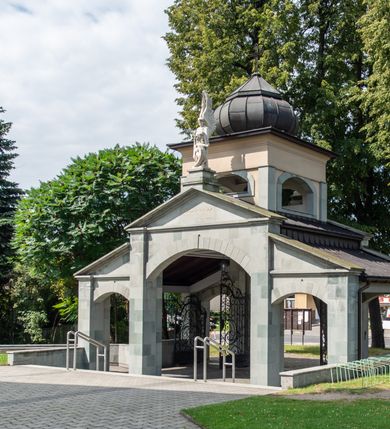 Zdjęcie nr 22: Orientowany kościół św. Urbana w Brzeszczach został wzniesiony w układzie czteroprzęsłowej nawy z prostokątnie zamkniętym prezbiterium, na przedłużeniu którego wzniesiono mniejszą, dwupiętrową zakrystię na rzucie prostokąta. Od północy i od południa do nawy dobudowano po jednej kaplicy, łącząc kaplicę południową z dawną zakrystią. Od zachodu do do nawy dostawiono masyw wieżowy z nieznacznie wysuniętą do przodu czworoboczną wieżę, flankowaną po bokach dwoma aneksami tej samej wysokości, co nawa. Kościół oraz dobudowane kaplice i zakrystia zostały przykryte miedzianymi dachami siodłowymi. Przy końcu nawy od wschodu na dachu nadwieszono wieżyczkę na sygnaturkę w formie latarni zwieńczonej baniastym hełmem. Podobną, bardziej przysadzistą wieżyczkę umieszczono na dachu kaplicy północnej. Elewacje zewnętrzne przeprute półokrągłymi oknami artykułowano za pomocą pilastrów o prostych głowicach wspartych na wysoki cokołach połączonych ze sobą gzymsem, podtrzymujących fazowane belkowanie przechodzące w profilowany gzyms koronujący. Elewacje wieży podzielona na dwie strefy rozdzielone belkowaniem wyłamanym w partii masywu wieżowego. Górna część wieży uzyskała ścięte naroża. W dolnej strefie w przyziemiu urządzono kruchtę, do której wejście na osi flankowane jest masywnym portalem utworzonym z dwóch czworobocznych podpór wspierających trójkątny przyczółek, ponad którym przepruto półokrągłe okno. Ponad gzymsem, w górnej strefie, zastosowano podział ramowy, ujmujący okulus, który pełni partię cokołową wspierającą flankujące górną część wieży pary pilastrów na każdej z czterech elewacji. Pilastry ustawione na postumentach o gładkich trzonach i kompozytowych głowicach wspierają fazowane belkowanie przechodzące w gzyms koronujący. Pomiędzy pilastrami przepruto półokrągłe okna z umieszczonymi nad nimi odcinkami belkowania. Ponad nimi zamontowano tarcze zegarowe. Wieżę zwieńczono baniastym hełmem z sześcioboczną latarnią nakrytą ostrosłupowym zwieńczeniem z krzyżem. Nawa główna otwiera się do kaplic bocznych za pomocą arkady. Wnętrze nakryto sklepieniem żaglastym. Całe wnętrze obiega marmurowa okładzina w formie boazerii. Chór muzyczny z prospektem organowym zajmuje całą szerokość nawy, wspierając się na dwóch filarach połączonych arkadą. Prosta balustrada chóru nad arkadą jest nieznacznie wypukła. W prezbiterium ustawiono ołtarz główny, a w kaplicach ołtarze boczne. Na ścianie północnej nawy przy prezbiterium zawieszono ambonę. 