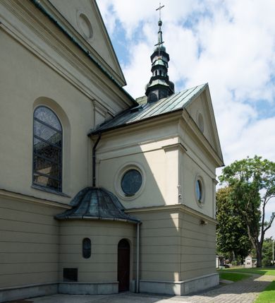 Zdjęcie nr 21: Orientowany kościół św. Urbana w Brzeszczach został wzniesiony w układzie czteroprzęsłowej nawy z prostokątnie zamkniętym prezbiterium, na przedłużeniu którego wzniesiono mniejszą, dwupiętrową zakrystię na rzucie prostokąta. Od północy i od południa do nawy dobudowano po jednej kaplicy, łącząc kaplicę południową z dawną zakrystią. Od zachodu do do nawy dostawiono masyw wieżowy z nieznacznie wysuniętą do przodu czworoboczną wieżę, flankowaną po bokach dwoma aneksami tej samej wysokości, co nawa. Kościół oraz dobudowane kaplice i zakrystia zostały przykryte miedzianymi dachami siodłowymi. Przy końcu nawy od wschodu na dachu nadwieszono wieżyczkę na sygnaturkę w formie latarni zwieńczonej baniastym hełmem. Podobną, bardziej przysadzistą wieżyczkę umieszczono na dachu kaplicy północnej. Elewacje zewnętrzne przeprute półokrągłymi oknami artykułowano za pomocą pilastrów o prostych głowicach wspartych na wysoki cokołach połączonych ze sobą gzymsem, podtrzymujących fazowane belkowanie przechodzące w profilowany gzyms koronujący. Elewacje wieży podzielona na dwie strefy rozdzielone belkowaniem wyłamanym w partii masywu wieżowego. Górna część wieży uzyskała ścięte naroża. W dolnej strefie w przyziemiu urządzono kruchtę, do której wejście na osi flankowane jest masywnym portalem utworzonym z dwóch czworobocznych podpór wspierających trójkątny przyczółek, ponad którym przepruto półokrągłe okno. Ponad gzymsem, w górnej strefie, zastosowano podział ramowy, ujmujący okulus, który pełni partię cokołową wspierającą flankujące górną część wieży pary pilastrów na każdej z czterech elewacji. Pilastry ustawione na postumentach o gładkich trzonach i kompozytowych głowicach wspierają fazowane belkowanie przechodzące w gzyms koronujący. Pomiędzy pilastrami przepruto półokrągłe okna z umieszczonymi nad nimi odcinkami belkowania. Ponad nimi zamontowano tarcze zegarowe. Wieżę zwieńczono baniastym hełmem z sześcioboczną latarnią nakrytą ostrosłupowym zwieńczeniem z krzyżem. Nawa główna otwiera się do kaplic bocznych za pomocą arkady. Wnętrze nakryto sklepieniem żaglastym. Całe wnętrze obiega marmurowa okładzina w formie boazerii. Chór muzyczny z prospektem organowym zajmuje całą szerokość nawy, wspierając się na dwóch filarach połączonych arkadą. Prosta balustrada chóru nad arkadą jest nieznacznie wypukła. W prezbiterium ustawiono ołtarz główny, a w kaplicach ołtarze boczne. Na ścianie północnej nawy przy prezbiterium zawieszono ambonę. 