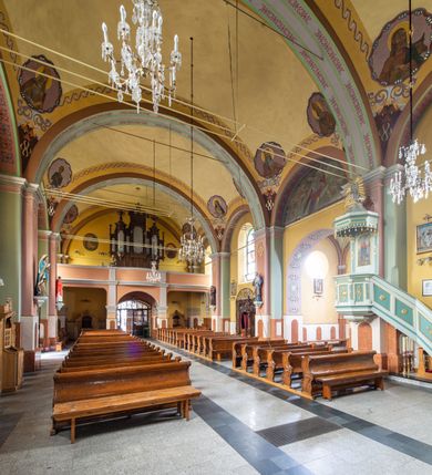 Zdjęcie nr 12: Orientowany kościół św. Urbana w Brzeszczach został wzniesiony w układzie czteroprzęsłowej nawy z prostokątnie zamkniętym prezbiterium, na przedłużeniu którego wzniesiono mniejszą, dwupiętrową zakrystię na rzucie prostokąta. Od północy i od południa do nawy dobudowano po jednej kaplicy, łącząc kaplicę południową z dawną zakrystią. Od zachodu do do nawy dostawiono masyw wieżowy z nieznacznie wysuniętą do przodu czworoboczną wieżę, flankowaną po bokach dwoma aneksami tej samej wysokości, co nawa. Kościół oraz dobudowane kaplice i zakrystia zostały przykryte miedzianymi dachami siodłowymi. Przy końcu nawy od wschodu na dachu nadwieszono wieżyczkę na sygnaturkę w formie latarni zwieńczonej baniastym hełmem. Podobną, bardziej przysadzistą wieżyczkę umieszczono na dachu kaplicy północnej. Elewacje zewnętrzne przeprute półokrągłymi oknami artykułowano za pomocą pilastrów o prostych głowicach wspartych na wysoki cokołach połączonych ze sobą gzymsem, podtrzymujących fazowane belkowanie przechodzące w profilowany gzyms koronujący. Elewacje wieży podzielona na dwie strefy rozdzielone belkowaniem wyłamanym w partii masywu wieżowego. Górna część wieży uzyskała ścięte naroża. W dolnej strefie w przyziemiu urządzono kruchtę, do której wejście na osi flankowane jest masywnym portalem utworzonym z dwóch czworobocznych podpór wspierających trójkątny przyczółek, ponad którym przepruto półokrągłe okno. Ponad gzymsem, w górnej strefie, zastosowano podział ramowy, ujmujący okulus, który pełni partię cokołową wspierającą flankujące górną część wieży pary pilastrów na każdej z czterech elewacji. Pilastry ustawione na postumentach o gładkich trzonach i kompozytowych głowicach wspierają fazowane belkowanie przechodzące w gzyms koronujący. Pomiędzy pilastrami przepruto półokrągłe okna z umieszczonymi nad nimi odcinkami belkowania. Ponad nimi zamontowano tarcze zegarowe. Wieżę zwieńczono baniastym hełmem z sześcioboczną latarnią nakrytą ostrosłupowym zwieńczeniem z krzyżem. Nawa główna otwiera się do kaplic bocznych za pomocą arkady. Wnętrze nakryto sklepieniem żaglastym. Całe wnętrze obiega marmurowa okładzina w formie boazerii. Chór muzyczny z prospektem organowym zajmuje całą szerokość nawy, wspierając się na dwóch filarach połączonych arkadą. Prosta balustrada chóru nad arkadą jest nieznacznie wypukła. W prezbiterium ustawiono ołtarz główny, a w kaplicach ołtarze boczne. Na ścianie północnej nawy przy prezbiterium zawieszono ambonę. 