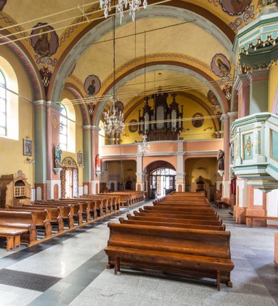 Zdjęcie nr 14: Orientowany kościół św. Urbana w Brzeszczach został wzniesiony w układzie czteroprzęsłowej nawy z prostokątnie zamkniętym prezbiterium, na przedłużeniu którego wzniesiono mniejszą, dwupiętrową zakrystię na rzucie prostokąta. Od północy i od południa do nawy dobudowano po jednej kaplicy, łącząc kaplicę południową z dawną zakrystią. Od zachodu do do nawy dostawiono masyw wieżowy z nieznacznie wysuniętą do przodu czworoboczną wieżę, flankowaną po bokach dwoma aneksami tej samej wysokości, co nawa. Kościół oraz dobudowane kaplice i zakrystia zostały przykryte miedzianymi dachami siodłowymi. Przy końcu nawy od wschodu na dachu nadwieszono wieżyczkę na sygnaturkę w formie latarni zwieńczonej baniastym hełmem. Podobną, bardziej przysadzistą wieżyczkę umieszczono na dachu kaplicy północnej. Elewacje zewnętrzne przeprute półokrągłymi oknami artykułowano za pomocą pilastrów o prostych głowicach wspartych na wysoki cokołach połączonych ze sobą gzymsem, podtrzymujących fazowane belkowanie przechodzące w profilowany gzyms koronujący. Elewacje wieży podzielona na dwie strefy rozdzielone belkowaniem wyłamanym w partii masywu wieżowego. Górna część wieży uzyskała ścięte naroża. W dolnej strefie w przyziemiu urządzono kruchtę, do której wejście na osi flankowane jest masywnym portalem utworzonym z dwóch czworobocznych podpór wspierających trójkątny przyczółek, ponad którym przepruto półokrągłe okno. Ponad gzymsem, w górnej strefie, zastosowano podział ramowy, ujmujący okulus, który pełni partię cokołową wspierającą flankujące górną część wieży pary pilastrów na każdej z czterech elewacji. Pilastry ustawione na postumentach o gładkich trzonach i kompozytowych głowicach wspierają fazowane belkowanie przechodzące w gzyms koronujący. Pomiędzy pilastrami przepruto półokrągłe okna z umieszczonymi nad nimi odcinkami belkowania. Ponad nimi zamontowano tarcze zegarowe. Wieżę zwieńczono baniastym hełmem z sześcioboczną latarnią nakrytą ostrosłupowym zwieńczeniem z krzyżem. Nawa główna otwiera się do kaplic bocznych za pomocą arkady. Wnętrze nakryto sklepieniem żaglastym. Całe wnętrze obiega marmurowa okładzina w formie boazerii. Chór muzyczny z prospektem organowym zajmuje całą szerokość nawy, wspierając się na dwóch filarach połączonych arkadą. Prosta balustrada chóru nad arkadą jest nieznacznie wypukła. W prezbiterium ustawiono ołtarz główny, a w kaplicach ołtarze boczne. Na ścianie północnej nawy przy prezbiterium zawieszono ambonę. 