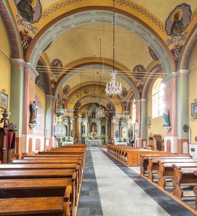 Zdjęcie nr 8: Orientowany kościół św. Urbana w Brzeszczach został wzniesiony w układzie czteroprzęsłowej nawy z prostokątnie zamkniętym prezbiterium, na przedłużeniu którego wzniesiono mniejszą, dwupiętrową zakrystię na rzucie prostokąta. Od północy i od południa do nawy dobudowano po jednej kaplicy, łącząc kaplicę południową z dawną zakrystią. Od zachodu do do nawy dostawiono masyw wieżowy z nieznacznie wysuniętą do przodu czworoboczną wieżę, flankowaną po bokach dwoma aneksami tej samej wysokości, co nawa. Kościół oraz dobudowane kaplice i zakrystia zostały przykryte miedzianymi dachami siodłowymi. Przy końcu nawy od wschodu na dachu nadwieszono wieżyczkę na sygnaturkę w formie latarni zwieńczonej baniastym hełmem. Podobną, bardziej przysadzistą wieżyczkę umieszczono na dachu kaplicy północnej. Elewacje zewnętrzne przeprute półokrągłymi oknami artykułowano za pomocą pilastrów o prostych głowicach wspartych na wysoki cokołach połączonych ze sobą gzymsem, podtrzymujących fazowane belkowanie przechodzące w profilowany gzyms koronujący. Elewacje wieży podzielona na dwie strefy rozdzielone belkowaniem wyłamanym w partii masywu wieżowego. Górna część wieży uzyskała ścięte naroża. W dolnej strefie w przyziemiu urządzono kruchtę, do której wejście na osi flankowane jest masywnym portalem utworzonym z dwóch czworobocznych podpór wspierających trójkątny przyczółek, ponad którym przepruto półokrągłe okno. Ponad gzymsem, w górnej strefie, zastosowano podział ramowy, ujmujący okulus, który pełni partię cokołową wspierającą flankujące górną część wieży pary pilastrów na każdej z czterech elewacji. Pilastry ustawione na postumentach o gładkich trzonach i kompozytowych głowicach wspierają fazowane belkowanie przechodzące w gzyms koronujący. Pomiędzy pilastrami przepruto półokrągłe okna z umieszczonymi nad nimi odcinkami belkowania. Ponad nimi zamontowano tarcze zegarowe. Wieżę zwieńczono baniastym hełmem z sześcioboczną latarnią nakrytą ostrosłupowym zwieńczeniem z krzyżem. Nawa główna otwiera się do kaplic bocznych za pomocą arkady. Wnętrze nakryto sklepieniem żaglastym. Całe wnętrze obiega marmurowa okładzina w formie boazerii. Chór muzyczny z prospektem organowym zajmuje całą szerokość nawy, wspierając się na dwóch filarach połączonych arkadą. Prosta balustrada chóru nad arkadą jest nieznacznie wypukła. W prezbiterium ustawiono ołtarz główny, a w kaplicach ołtarze boczne. Na ścianie północnej nawy przy prezbiterium zawieszono ambonę. 