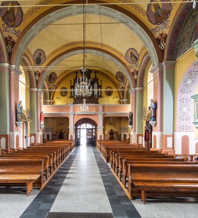 Zdjęcie nr 11: Orientowany kościół św. Urbana w Brzeszczach został wzniesiony w układzie czteroprzęsłowej nawy z prostokątnie zamkniętym prezbiterium, na przedłużeniu którego wzniesiono mniejszą, dwupiętrową zakrystię na rzucie prostokąta. Od północy i od południa do nawy dobudowano po jednej kaplicy, łącząc kaplicę południową z dawną zakrystią. Od zachodu do do nawy dostawiono masyw wieżowy z nieznacznie wysuniętą do przodu czworoboczną wieżę, flankowaną po bokach dwoma aneksami tej samej wysokości, co nawa. Kościół oraz dobudowane kaplice i zakrystia zostały przykryte miedzianymi dachami siodłowymi. Przy końcu nawy od wschodu na dachu nadwieszono wieżyczkę na sygnaturkę w formie latarni zwieńczonej baniastym hełmem. Podobną, bardziej przysadzistą wieżyczkę umieszczono na dachu kaplicy północnej. Elewacje zewnętrzne przeprute półokrągłymi oknami artykułowano za pomocą pilastrów o prostych głowicach wspartych na wysoki cokołach połączonych ze sobą gzymsem, podtrzymujących fazowane belkowanie przechodzące w profilowany gzyms koronujący. Elewacje wieży podzielona na dwie strefy rozdzielone belkowaniem wyłamanym w partii masywu wieżowego. Górna część wieży uzyskała ścięte naroża. W dolnej strefie w przyziemiu urządzono kruchtę, do której wejście na osi flankowane jest masywnym portalem utworzonym z dwóch czworobocznych podpór wspierających trójkątny przyczółek, ponad którym przepruto półokrągłe okno. Ponad gzymsem, w górnej strefie, zastosowano podział ramowy, ujmujący okulus, który pełni partię cokołową wspierającą flankujące górną część wieży pary pilastrów na każdej z czterech elewacji. Pilastry ustawione na postumentach o gładkich trzonach i kompozytowych głowicach wspierają fazowane belkowanie przechodzące w gzyms koronujący. Pomiędzy pilastrami przepruto półokrągłe okna z umieszczonymi nad nimi odcinkami belkowania. Ponad nimi zamontowano tarcze zegarowe. Wieżę zwieńczono baniastym hełmem z sześcioboczną latarnią nakrytą ostrosłupowym zwieńczeniem z krzyżem. Nawa główna otwiera się do kaplic bocznych za pomocą arkady. Wnętrze nakryto sklepieniem żaglastym. Całe wnętrze obiega marmurowa okładzina w formie boazerii. Chór muzyczny z prospektem organowym zajmuje całą szerokość nawy, wspierając się na dwóch filarach połączonych arkadą. Prosta balustrada chóru nad arkadą jest nieznacznie wypukła. W prezbiterium ustawiono ołtarz główny, a w kaplicach ołtarze boczne. Na ścianie północnej nawy przy prezbiterium zawieszono ambonę. 