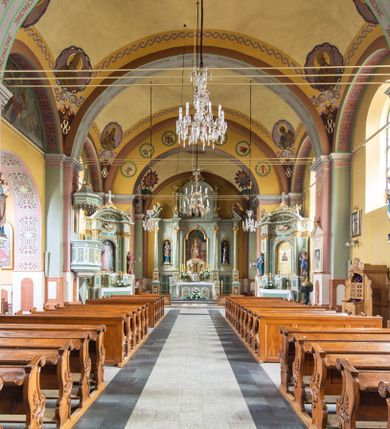 Zdjęcie nr 6: Orientowany kościół św. Urbana w Brzeszczach został wzniesiony w układzie czteroprzęsłowej nawy z prostokątnie zamkniętym prezbiterium, na przedłużeniu którego wzniesiono mniejszą, dwupiętrową zakrystię na rzucie prostokąta. Od północy i od południa do nawy dobudowano po jednej kaplicy, łącząc kaplicę południową z dawną zakrystią. Od zachodu do do nawy dostawiono masyw wieżowy z nieznacznie wysuniętą do przodu czworoboczną wieżę, flankowaną po bokach dwoma aneksami tej samej wysokości, co nawa. Kościół oraz dobudowane kaplice i zakrystia zostały przykryte miedzianymi dachami siodłowymi. Przy końcu nawy od wschodu na dachu nadwieszono wieżyczkę na sygnaturkę w formie latarni zwieńczonej baniastym hełmem. Podobną, bardziej przysadzistą wieżyczkę umieszczono na dachu kaplicy północnej. Elewacje zewnętrzne przeprute półokrągłymi oknami artykułowano za pomocą pilastrów o prostych głowicach wspartych na wysoki cokołach połączonych ze sobą gzymsem, podtrzymujących fazowane belkowanie przechodzące w profilowany gzyms koronujący. Elewacje wieży podzielona na dwie strefy rozdzielone belkowaniem wyłamanym w partii masywu wieżowego. Górna część wieży uzyskała ścięte naroża. W dolnej strefie w przyziemiu urządzono kruchtę, do której wejście na osi flankowane jest masywnym portalem utworzonym z dwóch czworobocznych podpór wspierających trójkątny przyczółek, ponad którym przepruto półokrągłe okno. Ponad gzymsem, w górnej strefie, zastosowano podział ramowy, ujmujący okulus, który pełni partię cokołową wspierającą flankujące górną część wieży pary pilastrów na każdej z czterech elewacji. Pilastry ustawione na postumentach o gładkich trzonach i kompozytowych głowicach wspierają fazowane belkowanie przechodzące w gzyms koronujący. Pomiędzy pilastrami przepruto półokrągłe okna z umieszczonymi nad nimi odcinkami belkowania. Ponad nimi zamontowano tarcze zegarowe. Wieżę zwieńczono baniastym hełmem z sześcioboczną latarnią nakrytą ostrosłupowym zwieńczeniem z krzyżem. Nawa główna otwiera się do kaplic bocznych za pomocą arkady. Wnętrze nakryto sklepieniem żaglastym. Całe wnętrze obiega marmurowa okładzina w formie boazerii. Chór muzyczny z prospektem organowym zajmuje całą szerokość nawy, wspierając się na dwóch filarach połączonych arkadą. Prosta balustrada chóru nad arkadą jest nieznacznie wypukła. W prezbiterium ustawiono ołtarz główny, a w kaplicach ołtarze boczne. Na ścianie północnej nawy przy prezbiterium zawieszono ambonę. 