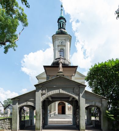 Zdjęcie nr 16: Orientowany kościół św. Urbana w Brzeszczach został wzniesiony w układzie czteroprzęsłowej nawy z prostokątnie zamkniętym prezbiterium, na przedłużeniu którego wzniesiono mniejszą, dwupiętrową zakrystię na rzucie prostokąta. Od północy i od południa do nawy dobudowano po jednej kaplicy, łącząc kaplicę południową z dawną zakrystią. Od zachodu do do nawy dostawiono masyw wieżowy z nieznacznie wysuniętą do przodu czworoboczną wieżę, flankowaną po bokach dwoma aneksami tej samej wysokości, co nawa. Kościół oraz dobudowane kaplice i zakrystia zostały przykryte miedzianymi dachami siodłowymi. Przy końcu nawy od wschodu na dachu nadwieszono wieżyczkę na sygnaturkę w formie latarni zwieńczonej baniastym hełmem. Podobną, bardziej przysadzistą wieżyczkę umieszczono na dachu kaplicy północnej. Elewacje zewnętrzne przeprute półokrągłymi oknami artykułowano za pomocą pilastrów o prostych głowicach wspartych na wysoki cokołach połączonych ze sobą gzymsem, podtrzymujących fazowane belkowanie przechodzące w profilowany gzyms koronujący. Elewacje wieży podzielona na dwie strefy rozdzielone belkowaniem wyłamanym w partii masywu wieżowego. Górna część wieży uzyskała ścięte naroża. W dolnej strefie w przyziemiu urządzono kruchtę, do której wejście na osi flankowane jest masywnym portalem utworzonym z dwóch czworobocznych podpór wspierających trójkątny przyczółek, ponad którym przepruto półokrągłe okno. Ponad gzymsem, w górnej strefie, zastosowano podział ramowy, ujmujący okulus, który pełni partię cokołową wspierającą flankujące górną część wieży pary pilastrów na każdej z czterech elewacji. Pilastry ustawione na postumentach o gładkich trzonach i kompozytowych głowicach wspierają fazowane belkowanie przechodzące w gzyms koronujący. Pomiędzy pilastrami przepruto półokrągłe okna z umieszczonymi nad nimi odcinkami belkowania. Ponad nimi zamontowano tarcze zegarowe. Wieżę zwieńczono baniastym hełmem z sześcioboczną latarnią nakrytą ostrosłupowym zwieńczeniem z krzyżem. Nawa główna otwiera się do kaplic bocznych za pomocą arkady. Wnętrze nakryto sklepieniem żaglastym. Całe wnętrze obiega marmurowa okładzina w formie boazerii. Chór muzyczny z prospektem organowym zajmuje całą szerokość nawy, wspierając się na dwóch filarach połączonych arkadą. Prosta balustrada chóru nad arkadą jest nieznacznie wypukła. W prezbiterium ustawiono ołtarz główny, a w kaplicach ołtarze boczne. Na ścianie północnej nawy przy prezbiterium zawieszono ambonę. 