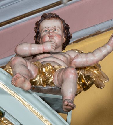 Zdjęcie nr 15: Ołtarz przyścienny, prostopadłościenny, z antepedium, na którym umieszczone są rzeźbione litery IHS; mensa drewniana z kamiennym portatylem. Na mensie znajduje się tabernakulum o kształcie graniastosłupa, z drzwiczkami ozdobionymi rzeźbionym kielichem z hostią. Nastawa ołtarzowa jest architektoniczna, jednoosiowa, jednokondygnacyjna ze zwieńczeniem. Osadzona na podwójnym postumencie, flankowana pilastrami o kompozytowych kapitelach i kanelowanymi kolumnami o kompozytowych kapitelach, które podtrzymują belkowanie. Ponad belkowaniem znajduje się przełamany przyczółek w formie łuku półkolistego, bogato profilowany, ozdobiony ulistnionymi konsolkami i rozetami oraz girlandami z owoców. W partii fryzu kartusz o fantazyjnym wykroju, ujęty wolutami i listkami akantu. Na belkowaniu siedzą po bokach nagie putta, odziane w opaski na biodrach, a pośrodku znajduje się krzyż osadzony na postumencie z liśćmi. Po obu stronach ołtarza na konsolach o krawędziach ozdobionych ornamentem małżowinowym stoją figury trudnych do identyfikacji świętych, być może apostołów. W centralnej części ołtarza wnęka prostokątna, zamknięta łukiem półkolistym. W niej obraz z przedstawieniem „Jezu ufam Tobie”. 
