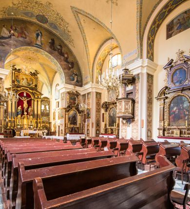 Zdjęcie nr 11: Kompleks klasztorny jest na rzucie czworoboku, z wirydarzem pośrodku i kościołem przylegającym od wschodu. Kościół, zwrócony w kierunku południowo-wschodnim, jest budowlą murowaną z cegły i kamienia, na rzucie podłużnym. Korpus jest jednonawowy i dwuprzęsłowy. Do dwuprzęsłowego prezbiterium na rzucie prostokąta od wschodu przylega zakrystia, do korpusu nawowego kaplica na rzucie ośmioboku z niewysoką przyległością, natomiast do fasady kruchta. Nawa i prezbiterium przekryte są sklepieniami kolebkowymi z lunetami wspartymi na masywnych półfilarach. Przestrzeń prezbiterium od korpusu nawowego oddziela półkolista arkada łuku tęczowego. Artykulację ścian na zewnątrz kościoła stanowią ujmujące okna duże, prostokątne płyciny. Korpus i prezbiterium obiega gzyms koronujący. Szczyt kościoła trójkątny, kruchty w formie nadwieszonego łuku z wycinka elipsy z wklęsłymi uskokami. Do wnętrza prowadzą dwa otwory drzwiowe po wschodniej i północnej stronie kruchty z parą prostokątnych, dwuskrzydłowych drzwi. W szczycie fasady płytka wnęka w kształcie stojącego prostokąta zamkniętego półkoliście z wizerunkiem Niepokalanego Poczęcia Najświętszej Marii Panny, ujęta trzema okrągłymi oknami. W szczycie kruchty analogiczna wnęka z figurą św. Floriana. Pośrodku fasady duże okno w kształcie stojącego prostokąta zamkniętego łukiem odcinkowym. Analogiczne okna w przęsłach korpusu i prezbiterium oraz na jego zamknięciu. Szczyt prezbiterium artykułuje płytka wnęka w kształcie stojącego prostokąta zamkniętego półkoliście z wizerunkiem św. Franciszka adorującego Jezusa na krzyżu flankowana parą okrągłych okien. Korpus i prezbiterium przekryte dachami dwuspadowymi, nad prezbiterium wieżyczka na sygnaturkę. Ściany kaplicy bocznej w formie półkolistych arkad, wypełnionych dużymi oknami z dekoracją maswerkową w górnej partii i przeszklonym otworem drzwiowym, zwieńczonych trójkątnymi szczytami. Ujmują je pary pilastrów, szczyty artykułuje fryz arkadkowy. Kaplicę wieńczy hełm pinaklowy z latarnią. Ściany sąsiedniej przyległości, nakrytej dachem pulpitowym i zakrystii z dachem trójspadowym, artykułuje fryz arkadkowy z lizenami. Tynki pomalowane są w odcieniach żółci. 