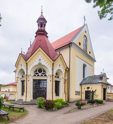 Zdjęcie nr 1: Kompleks klasztorny jest na rzucie czworoboku, z wirydarzem pośrodku i kościołem przylegającym od wschodu. Kościół, zwrócony w kierunku południowo-wschodnim, jest budowlą murowaną z cegły i kamienia, na rzucie podłużnym. Korpus jest jednonawowy i dwuprzęsłowy. Do dwuprzęsłowego prezbiterium na rzucie prostokąta od wschodu przylega zakrystia, do korpusu nawowego kaplica na rzucie ośmioboku z niewysoką przyległością, natomiast do fasady kruchta. Nawa i prezbiterium przekryte są sklepieniami kolebkowymi z lunetami wspartymi na masywnych półfilarach. Przestrzeń prezbiterium od korpusu nawowego oddziela półkolista arkada łuku tęczowego. Artykulację ścian na zewnątrz kościoła stanowią ujmujące okna duże, prostokątne płyciny. Korpus i prezbiterium obiega gzyms koronujący. Szczyt kościoła trójkątny, kruchty w formie nadwieszonego łuku z wycinka elipsy z wklęsłymi uskokami. Do wnętrza prowadzą dwa otwory drzwiowe po wschodniej i północnej stronie kruchty z parą prostokątnych, dwuskrzydłowych drzwi. W szczycie fasady płytka wnęka w kształcie stojącego prostokąta zamkniętego półkoliście z wizerunkiem Niepokalanego Poczęcia Najświętszej Marii Panny, ujęta trzema okrągłymi oknami. W szczycie kruchty analogiczna wnęka z figurą św. Floriana. Pośrodku fasady duże okno w kształcie stojącego prostokąta zamkniętego łukiem odcinkowym. Analogiczne okna w przęsłach korpusu i prezbiterium oraz na jego zamknięciu. Szczyt prezbiterium artykułuje płytka wnęka w kształcie stojącego prostokąta zamkniętego półkoliście z wizerunkiem św. Franciszka adorującego Jezusa na krzyżu flankowana parą okrągłych okien. Korpus i prezbiterium przekryte dachami dwuspadowymi, nad prezbiterium wieżyczka na sygnaturkę. Ściany kaplicy bocznej w formie półkolistych arkad, wypełnionych dużymi oknami z dekoracją maswerkową w górnej partii i przeszklonym otworem drzwiowym, zwieńczonych trójkątnymi szczytami. Ujmują je pary pilastrów, szczyty artykułuje fryz arkadkowy. Kaplicę wieńczy hełm pinaklowy z latarnią. Ściany sąsiedniej przyległości, nakrytej dachem pulpitowym i zakrystii z dachem trójspadowym, artykułuje fryz arkadkowy z lizenami. Tynki pomalowane są w odcieniach żółci. 
