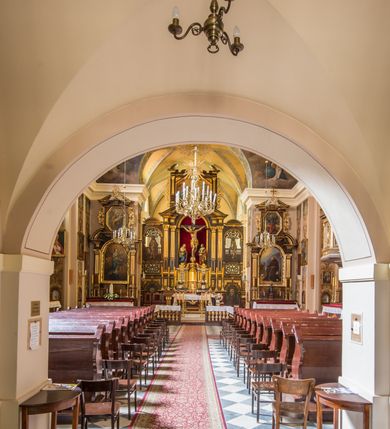 Zdjęcie nr 12: Kompleks klasztorny jest na rzucie czworoboku, z wirydarzem pośrodku i kościołem przylegającym od wschodu. Kościół, zwrócony w kierunku południowo-wschodnim, jest budowlą murowaną z cegły i kamienia, na rzucie podłużnym. Korpus jest jednonawowy i dwuprzęsłowy. Do dwuprzęsłowego prezbiterium na rzucie prostokąta od wschodu przylega zakrystia, do korpusu nawowego kaplica na rzucie ośmioboku z niewysoką przyległością, natomiast do fasady kruchta. Nawa i prezbiterium przekryte są sklepieniami kolebkowymi z lunetami wspartymi na masywnych półfilarach. Przestrzeń prezbiterium od korpusu nawowego oddziela półkolista arkada łuku tęczowego. Artykulację ścian na zewnątrz kościoła stanowią ujmujące okna duże, prostokątne płyciny. Korpus i prezbiterium obiega gzyms koronujący. Szczyt kościoła trójkątny, kruchty w formie nadwieszonego łuku z wycinka elipsy z wklęsłymi uskokami. Do wnętrza prowadzą dwa otwory drzwiowe po wschodniej i północnej stronie kruchty z parą prostokątnych, dwuskrzydłowych drzwi. W szczycie fasady płytka wnęka w kształcie stojącego prostokąta zamkniętego półkoliście z wizerunkiem Niepokalanego Poczęcia Najświętszej Marii Panny, ujęta trzema okrągłymi oknami. W szczycie kruchty analogiczna wnęka z figurą św. Floriana. Pośrodku fasady duże okno w kształcie stojącego prostokąta zamkniętego łukiem odcinkowym. Analogiczne okna w przęsłach korpusu i prezbiterium oraz na jego zamknięciu. Szczyt prezbiterium artykułuje płytka wnęka w kształcie stojącego prostokąta zamkniętego półkoliście z wizerunkiem św. Franciszka adorującego Jezusa na krzyżu flankowana parą okrągłych okien. Korpus i prezbiterium przekryte dachami dwuspadowymi, nad prezbiterium wieżyczka na sygnaturkę. Ściany kaplicy bocznej w formie półkolistych arkad, wypełnionych dużymi oknami z dekoracją maswerkową w górnej partii i przeszklonym otworem drzwiowym, zwieńczonych trójkątnymi szczytami. Ujmują je pary pilastrów, szczyty artykułuje fryz arkadkowy. Kaplicę wieńczy hełm pinaklowy z latarnią. Ściany sąsiedniej przyległości, nakrytej dachem pulpitowym i zakrystii z dachem trójspadowym, artykułuje fryz arkadkowy z lizenami. Tynki pomalowane są w odcieniach żółci. 