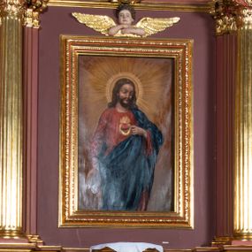 Zdjęcie nr 1: Ołtarz architektoniczny, jednoosiowy, jednokondygnacyjny, ze zwieńczeniem. Retabulum osadzone jest na wysokim, zdwojonym, zryzalitowanym uskokowo cokole. Ołtarz jest prostopadłościenny z drewnianą mensą. Pośrodku mensy znajduje się tabernakulum w formie prostopadłościennej szafki o lekko wypukłej przedniej ściance. Z przodu naroża ujmuje para półkolumienek, z tyłu półwałków. Prostokątne, zamknięte łukiem wklęsło-wypukłym drzwiczki zdobi polichromowane przedstawienie kielicha eucharystycznego na obłokach. Część środkową retabulum ujmuje para kolumn o żłobkowanych trzonach i korynckich kapitelach, ustawionych na tle zdwojonych pilastrów. Podpory dźwigają wyłamujące się ponad nimi belkowanie o silnie wysuniętym gzymsie. Zwieńczenie ma formę aediculi ujętej parą pilastrów i spływów wolutowych, zamkniętej trójkątnym przyczółkiem. Dodatkowo ujęta jest ona przerwanym, półkolistym przyczółkiem. Płycina antepedium jest w kształcie leżącego prostokąta z płaskorzeźbionym motywem złoconego, gorejącego serca, krzyża i kotwicy na tle srebrzonych obłoków ujętych promienistą glorią. Płyciny górnego cokołu (predelli) wypełnia stylizowana ornamentyka roślinna. Część środkową ujmuje para ażurowych uszaków z motywem kwiatu oraz wici akantu. U góry, pośrodku znajduje się uskrzydlona główka anielska. Powyżej, w partii belkowania, którego gzyms zdobi kostokowanie, umieszczony jest kartusz herbowy z monogramem maryjnym. Fryz zdobi stylizowana wić roślinna oraz para uskrzydlonych główek anielskich, natomiast zwieńczenie retabulum m.in. motywy roślinne, rozetki i kampanule. Szczyt tworzy podtrzymująca koronę para aniołów o sylwetkach od pasa w dół w formie liści akantu. Na przerwanym przyczółku znajduje się para przysiadających aniołów w sukniach w kolorze jasnofioletowym i pomarańczowym oraz złoconych płaszczach. Pole w części środkowej ma kształt stojącego prostokąta ujętego profilowaną, złoconą ramą. W środku znajduje się wizerunek Najświętszego Serca Jezusa. Pole w zwieńczeniu ma kształt stojącego owalu ujętego złoconą ramą w formie wieńca laurowego. Zawiera scenę Chrztu Jezusa w Jordanie. 
Struktura retabulum utrzymana jest w odcieniach brązu, partie detalu architektonicznego i ornamentyka są złocone. 
