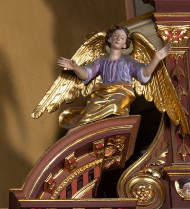 Zdjęcie nr 6: Ołtarz architektoniczny, jednoosiowy, jednokondygnacyjny, ze zwieńczeniem. Retabulum osadzone jest na wysokim, zdwojonym, zryzalitowanym uskokowo cokole. Ołtarz jest prostopadłościenny z drewnianą mensą. Pośrodku mensy znajduje się tabernakulum w formie prostopadłościennej szafki o lekko wypukłej przedniej ściance. Z przodu naroża ujmuje para półkolumienek, z tyłu półwałków. Prostokątne, zamknięte łukiem wklęsło-wypukłym drzwiczki zdobi polichromowane przedstawienie kielicha eucharystycznego na obłokach. Część środkową retabulum ujmuje para kolumn o żłobkowanych trzonach i korynckich kapitelach, ustawionych na tle zdwojonych pilastrów. Podpory dźwigają wyłamujące się ponad nimi belkowanie o silnie wysuniętym gzymsie. Zwieńczenie ma formę aediculi ujętej parą pilastrów i spływów wolutowych, zamkniętej trójkątnym przyczółkiem. Dodatkowo ujęta jest ona przerwanym, półkolistym przyczółkiem. Płycina antepedium jest w kształcie leżącego prostokąta z płaskorzeźbionym motywem złoconego, gorejącego serca, krzyża i kotwicy na tle srebrzonych obłoków ujętych promienistą glorią. Płyciny górnego cokołu (predelli) wypełnia stylizowana ornamentyka roślinna. Część środkową ujmuje para ażurowych uszaków z motywem kwiatu oraz wici akantu. U góry, pośrodku znajduje się uskrzydlona główka anielska. Powyżej, w partii belkowania, którego gzyms zdobi kostokowanie, umieszczony jest kartusz herbowy z monogramem maryjnym. Fryz zdobi stylizowana wić roślinna oraz para uskrzydlonych główek anielskich, natomiast zwieńczenie retabulum m.in. motywy roślinne, rozetki i kampanule. Szczyt tworzy podtrzymująca koronę para aniołów o sylwetkach od pasa w dół w formie liści akantu. Na przerwanym przyczółku znajduje się para przysiadających aniołów w sukniach w kolorze jasnofioletowym i pomarańczowym oraz złoconych płaszczach. Pole w części środkowej ma kształt stojącego prostokąta ujętego profilowaną, złoconą ramą. W środku znajduje się wizerunek Najświętszego Serca Jezusa. Pole w zwieńczeniu ma kształt stojącego owalu ujętego złoconą ramą w formie wieńca laurowego. Zawiera scenę Chrztu Jezusa w Jordanie. 
Struktura retabulum utrzymana jest w odcieniach brązu, partie detalu architektonicznego i ornamentyka są złocone. 
