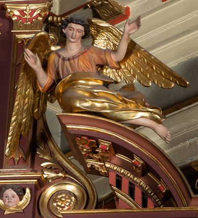 Zdjęcie nr 9: Ołtarz architektoniczny, jednoosiowy, jednokondygnacyjny, ze zwieńczeniem. Retabulum osadzone jest na wysokim, zdwojonym, zryzalitowanym uskokowo cokole. Ołtarz jest prostopadłościenny z drewnianą mensą. Pośrodku mensy znajduje się tabernakulum w formie prostopadłościennej szafki o lekko wypukłej przedniej ściance. Z przodu naroża ujmuje para półkolumienek, z tyłu półwałków. Prostokątne, zamknięte łukiem wklęsło-wypukłym drzwiczki zdobi polichromowane przedstawienie kielicha eucharystycznego na obłokach. Część środkową retabulum ujmuje para kolumn o żłobkowanych trzonach i korynckich kapitelach, ustawionych na tle zdwojonych pilastrów. Podpory dźwigają wyłamujące się ponad nimi belkowanie o silnie wysuniętym gzymsie. Zwieńczenie ma formę aediculi ujętej parą pilastrów i spływów wolutowych, zamkniętej trójkątnym przyczółkiem. Dodatkowo ujęta jest ona przerwanym, półkolistym przyczółkiem. Płycina antepedium jest w kształcie leżącego prostokąta z płaskorzeźbionym motywem złoconego, gorejącego serca, krzyża i kotwicy na tle srebrzonych obłoków ujętych promienistą glorią. Płyciny górnego cokołu (predelli) wypełnia stylizowana ornamentyka roślinna. Część środkową ujmuje para ażurowych uszaków z motywem kwiatu oraz wici akantu. U góry, pośrodku znajduje się uskrzydlona główka anielska. Powyżej, w partii belkowania, którego gzyms zdobi kostokowanie, umieszczony jest kartusz herbowy z monogramem maryjnym. Fryz zdobi stylizowana wić roślinna oraz para uskrzydlonych główek anielskich, natomiast zwieńczenie retabulum m.in. motywy roślinne, rozetki i kampanule. Szczyt tworzy podtrzymująca koronę para aniołów o sylwetkach od pasa w dół w formie liści akantu. Na przerwanym przyczółku znajduje się para przysiadających aniołów w sukniach w kolorze jasnofioletowym i pomarańczowym oraz złoconych płaszczach. Pole w części środkowej ma kształt stojącego prostokąta ujętego profilowaną, złoconą ramą. W środku znajduje się wizerunek Najświętszego Serca Jezusa. Pole w zwieńczeniu ma kształt stojącego owalu ujętego złoconą ramą w formie wieńca laurowego. Zawiera scenę Chrztu Jezusa w Jordanie. 
Struktura retabulum utrzymana jest w odcieniach brązu, partie detalu architektonicznego i ornamentyka są złocone. 
